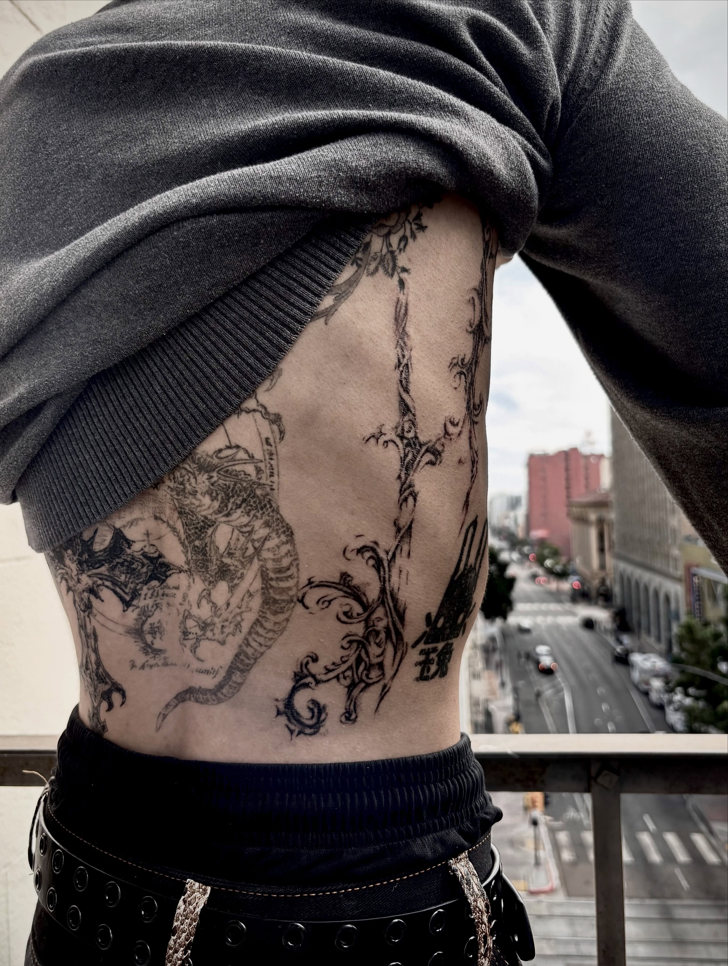 Dragon and floral black and grey tattoo on the thigh by @douohv