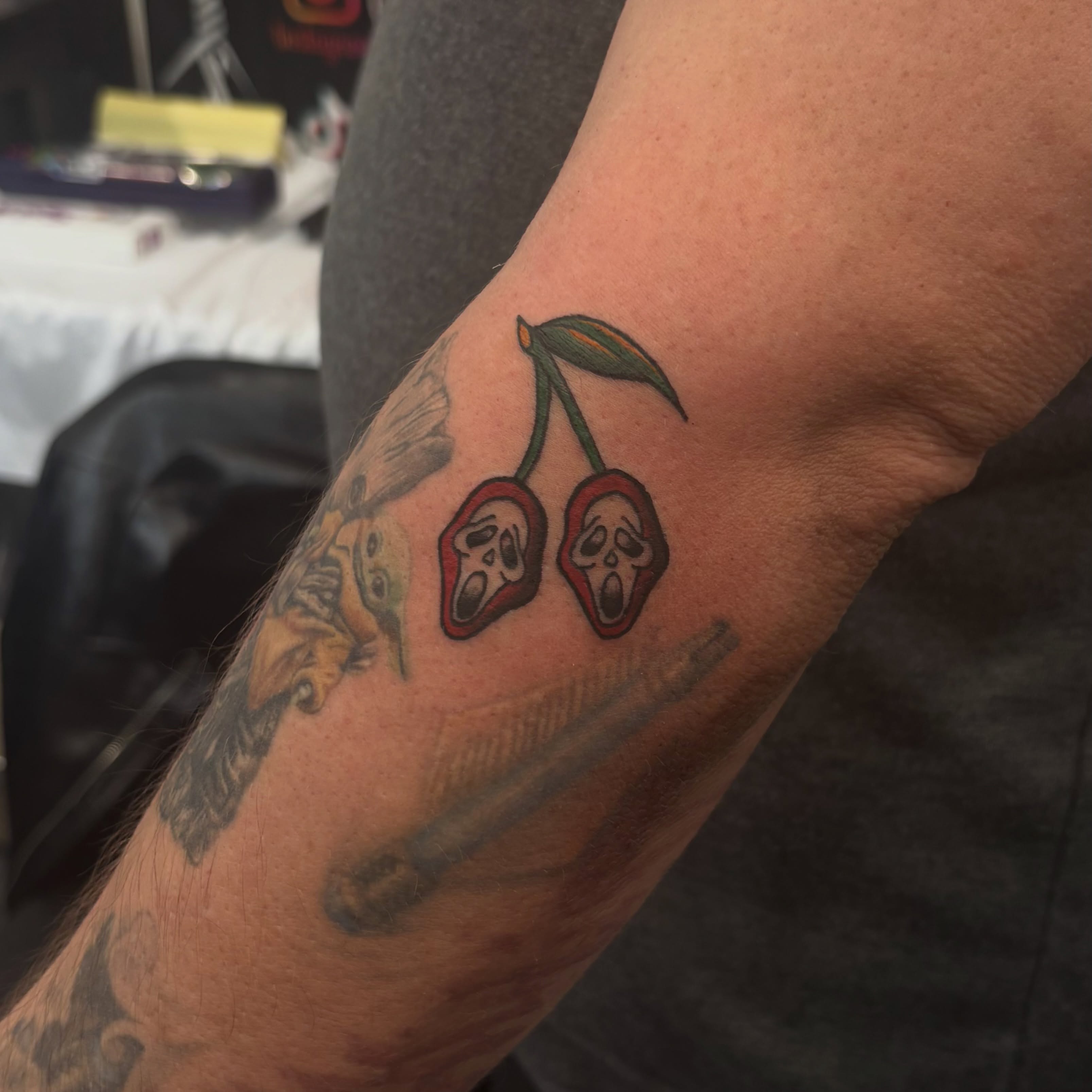Cherry skulls American traditional tattoo on the forearm by Nyah Ramirez