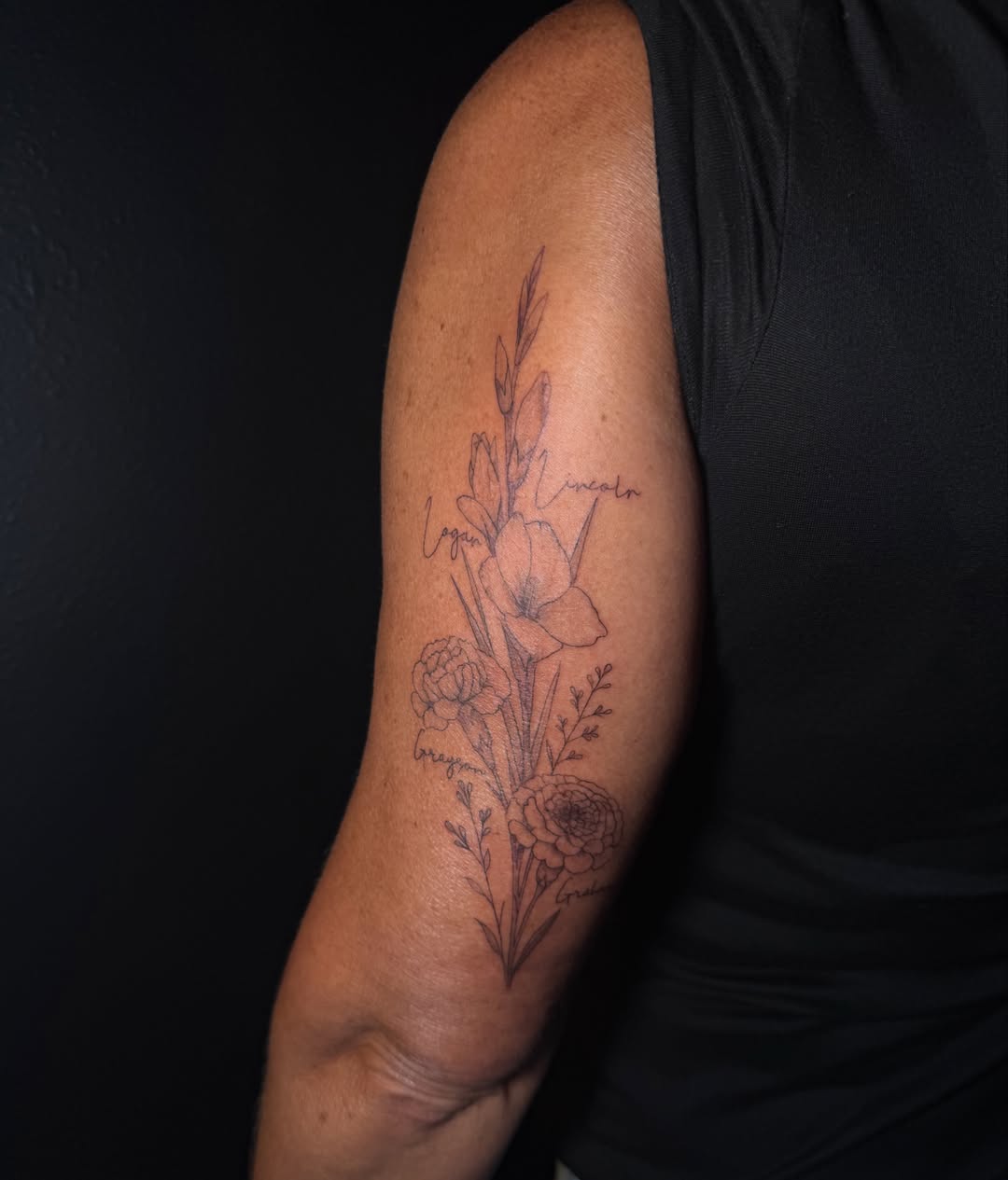 Floral arrangement black and grey tattoo on the forearm by Ink Darling, Carlisle, Iowa