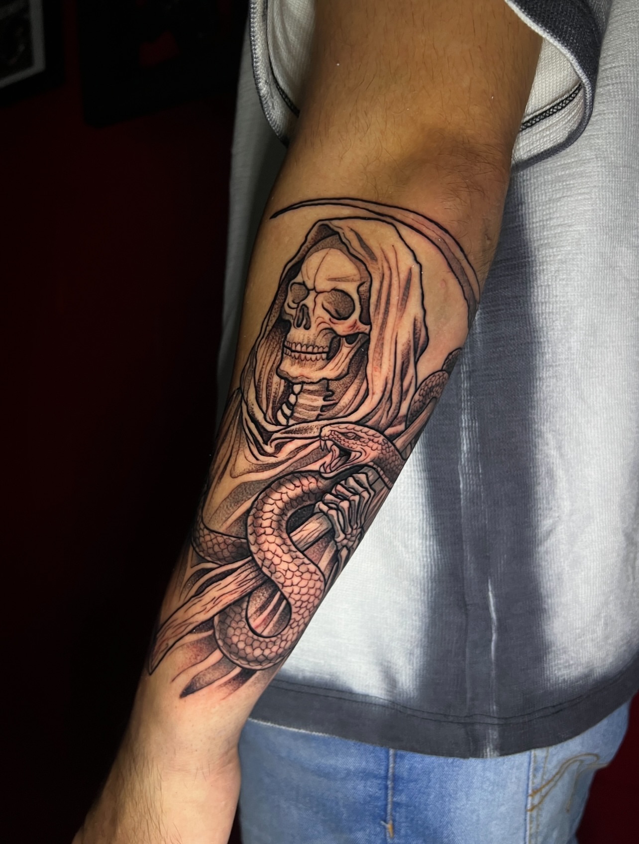 Reaper with snake black and grey tattoo on the forearm by El Salvador Tattoo Artist