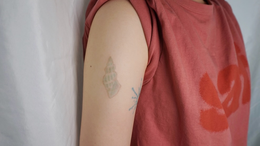 Shell geometric tattoo on the upper arm by 매실 * handpoke