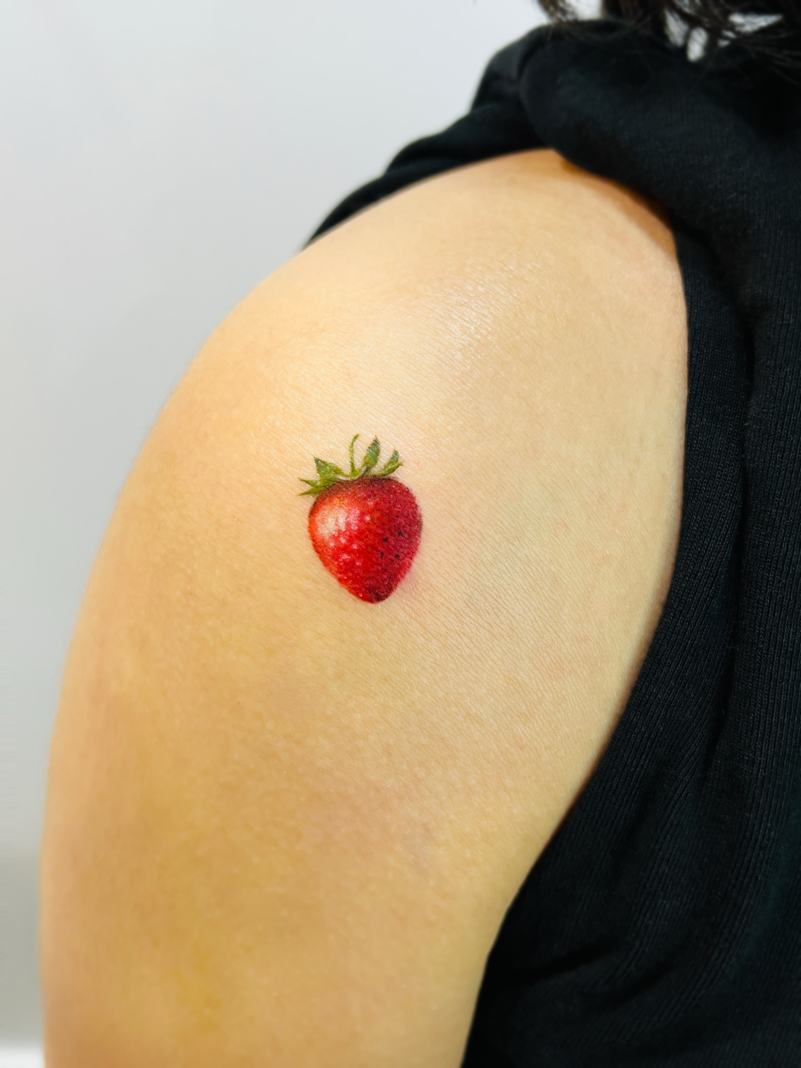 Strawberry realism tattoo on the shoulder by Purinn
