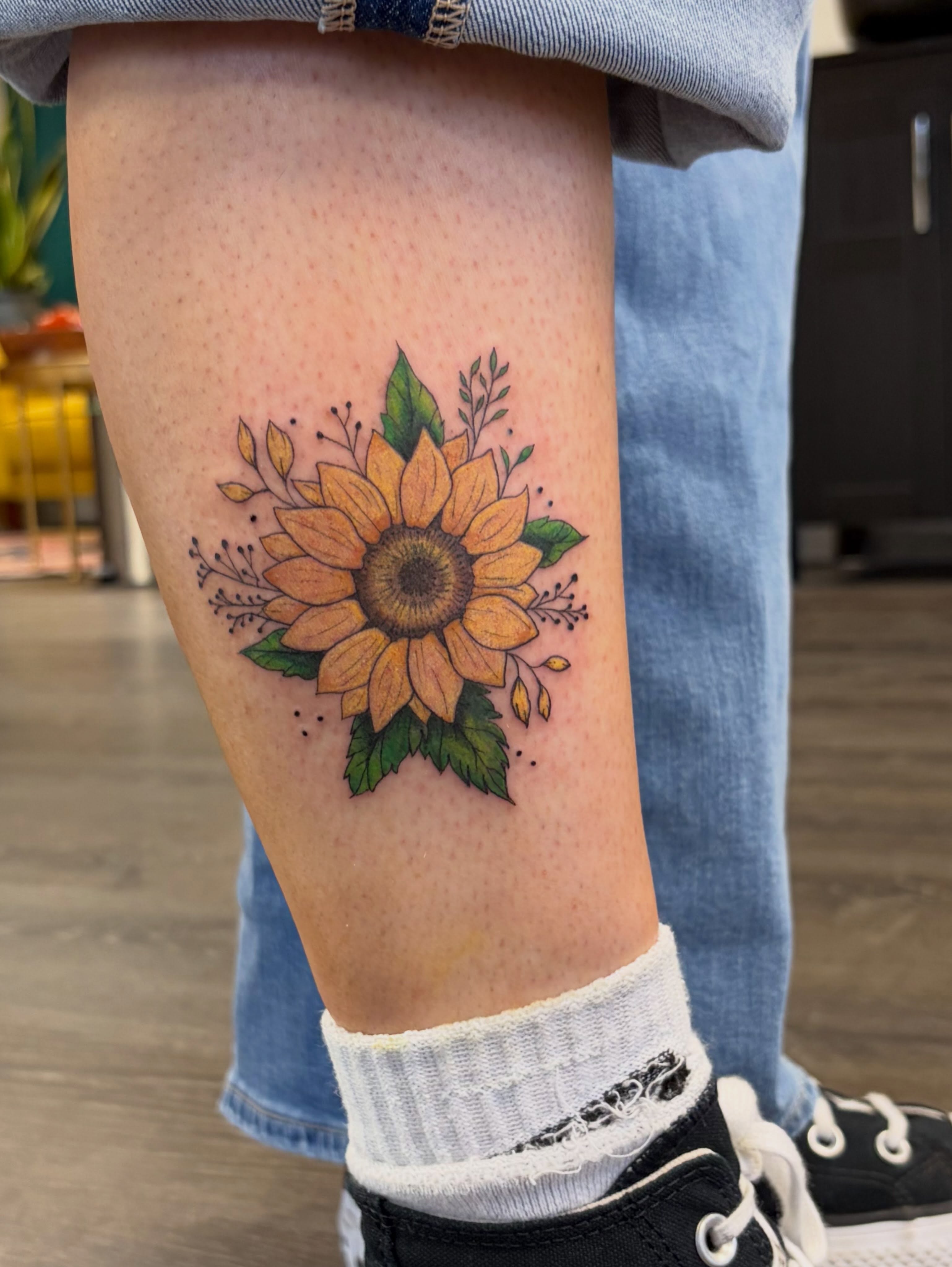 Sunflower dotwork tattoo on the calf by Deni Carolina