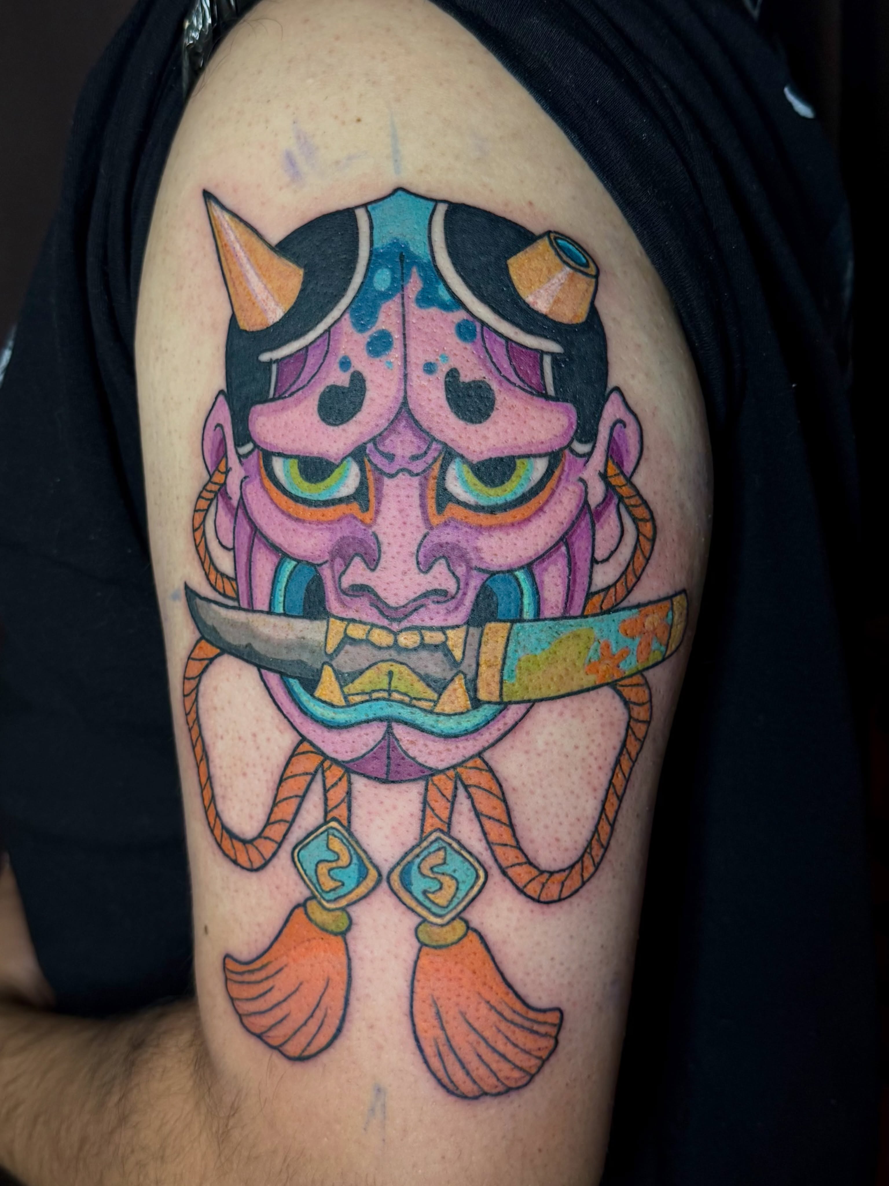 Mask with sword new school tattoo on the shoulder by Minxxy Tattoos