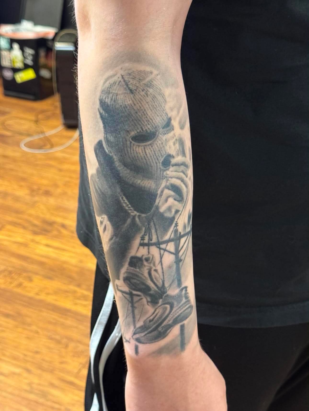 Mask and headphones realism tattoo on the forearm by Kyle J. Bishop