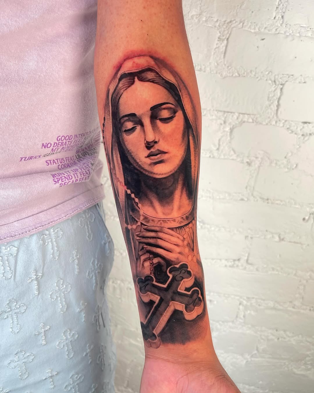 Virgin Mary with rosary and cross Chicano tattoo on the forearm by Authentics NYC