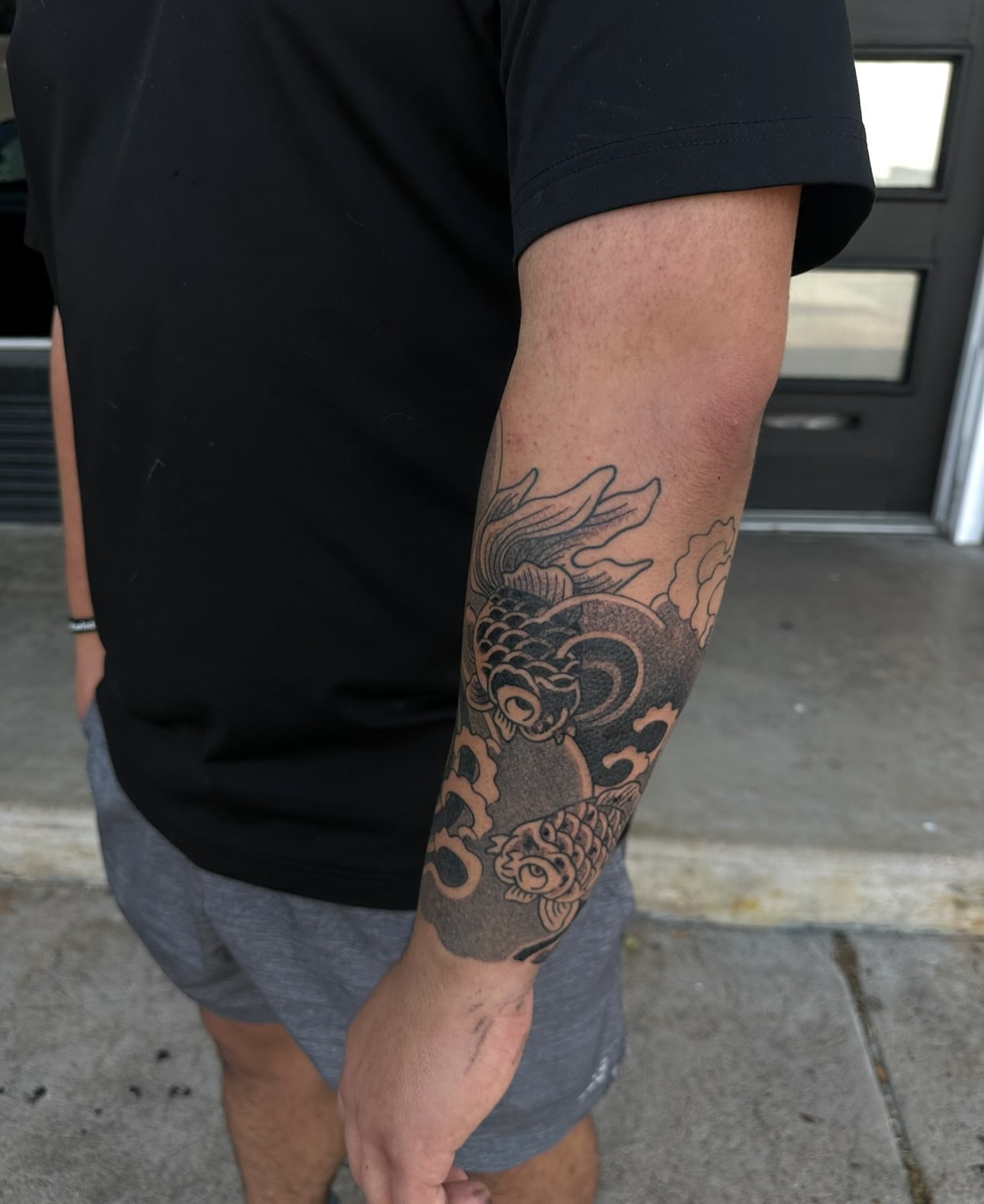 Koi fish black and grey tattoo on the forearm by Logan Perry