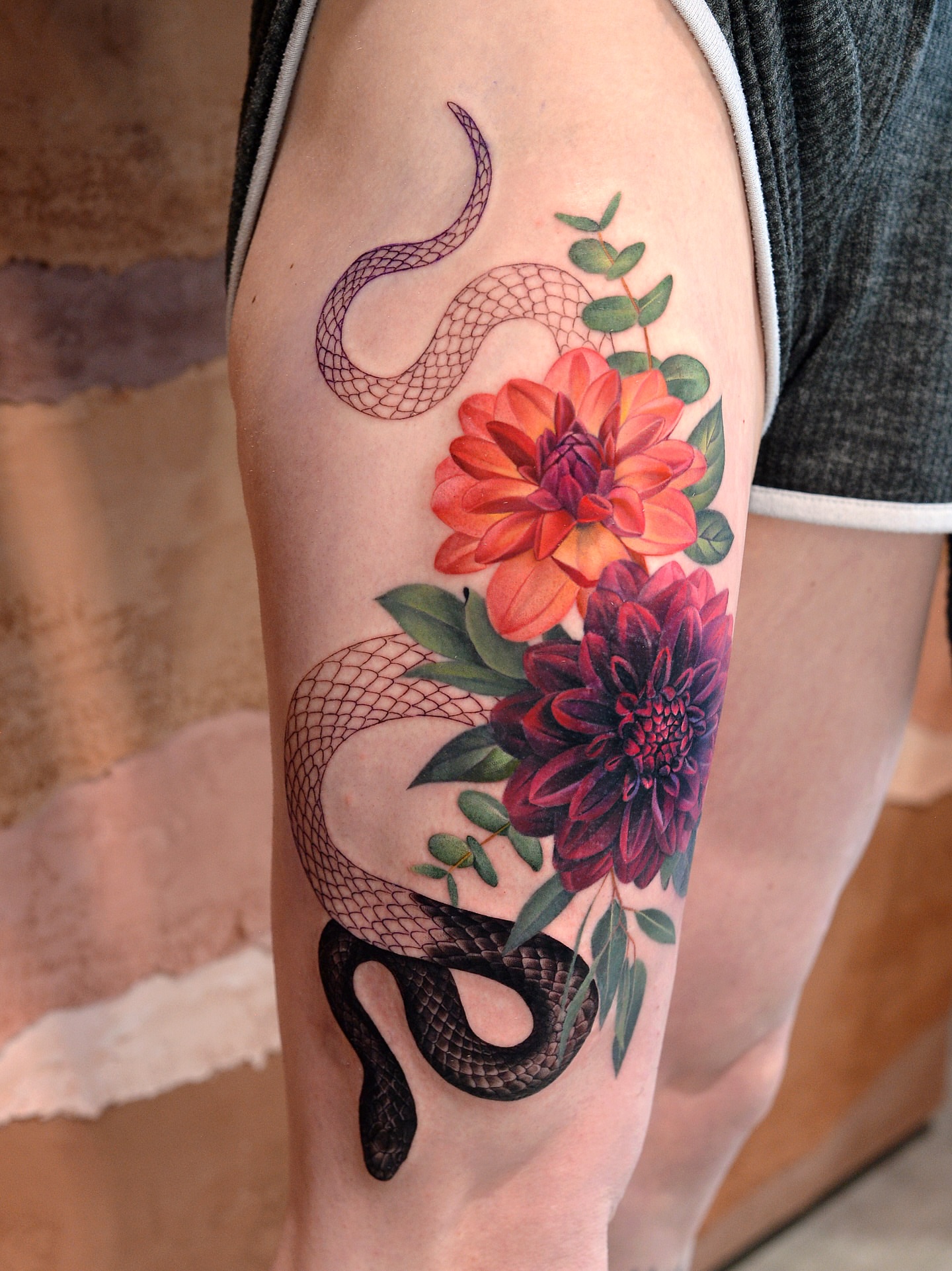 Snake and flowers realism tattoo on the thigh by Joice Wang