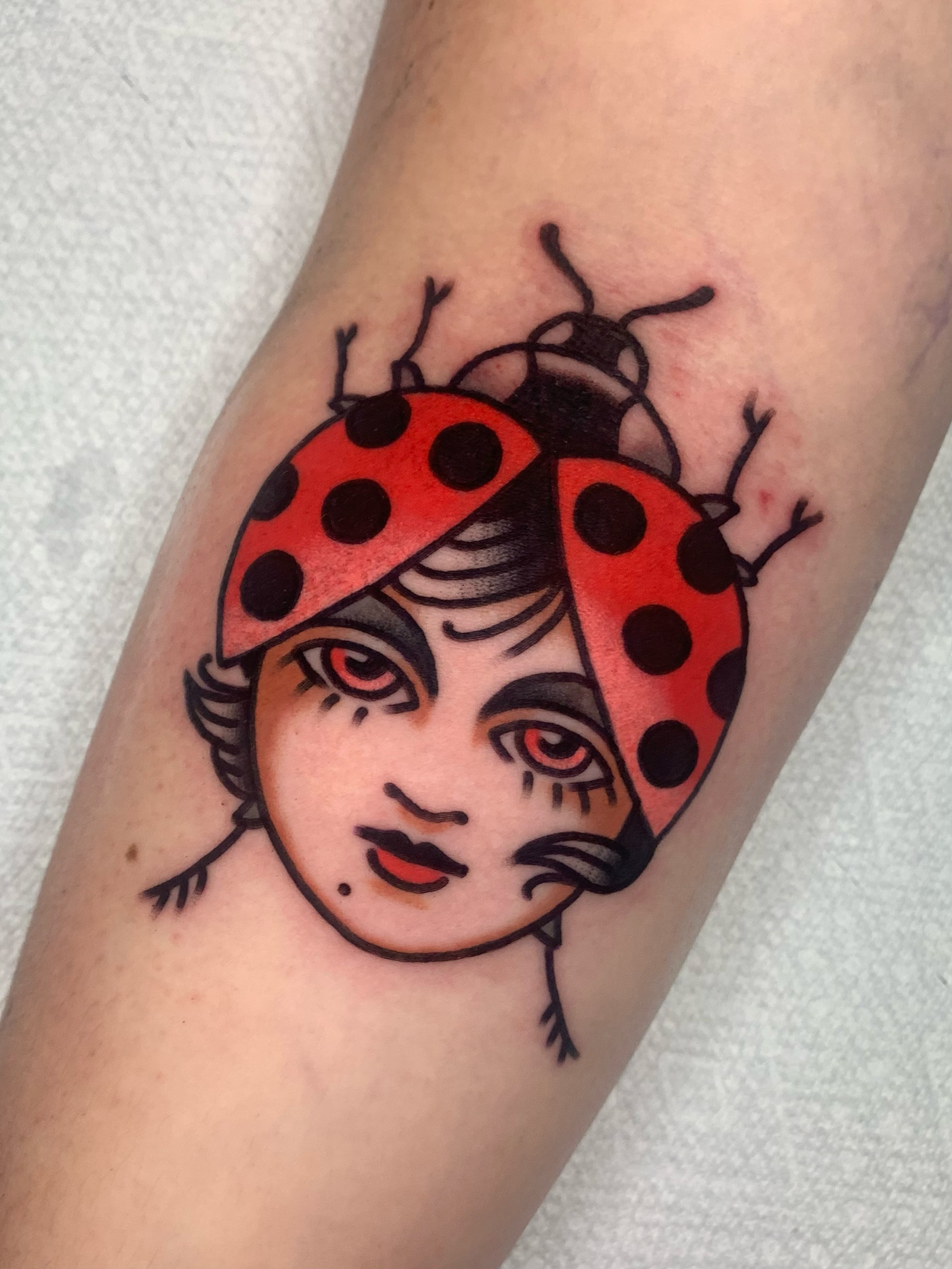 Ladybug American traditional tattoo on the forearm by Shawn VanKirk