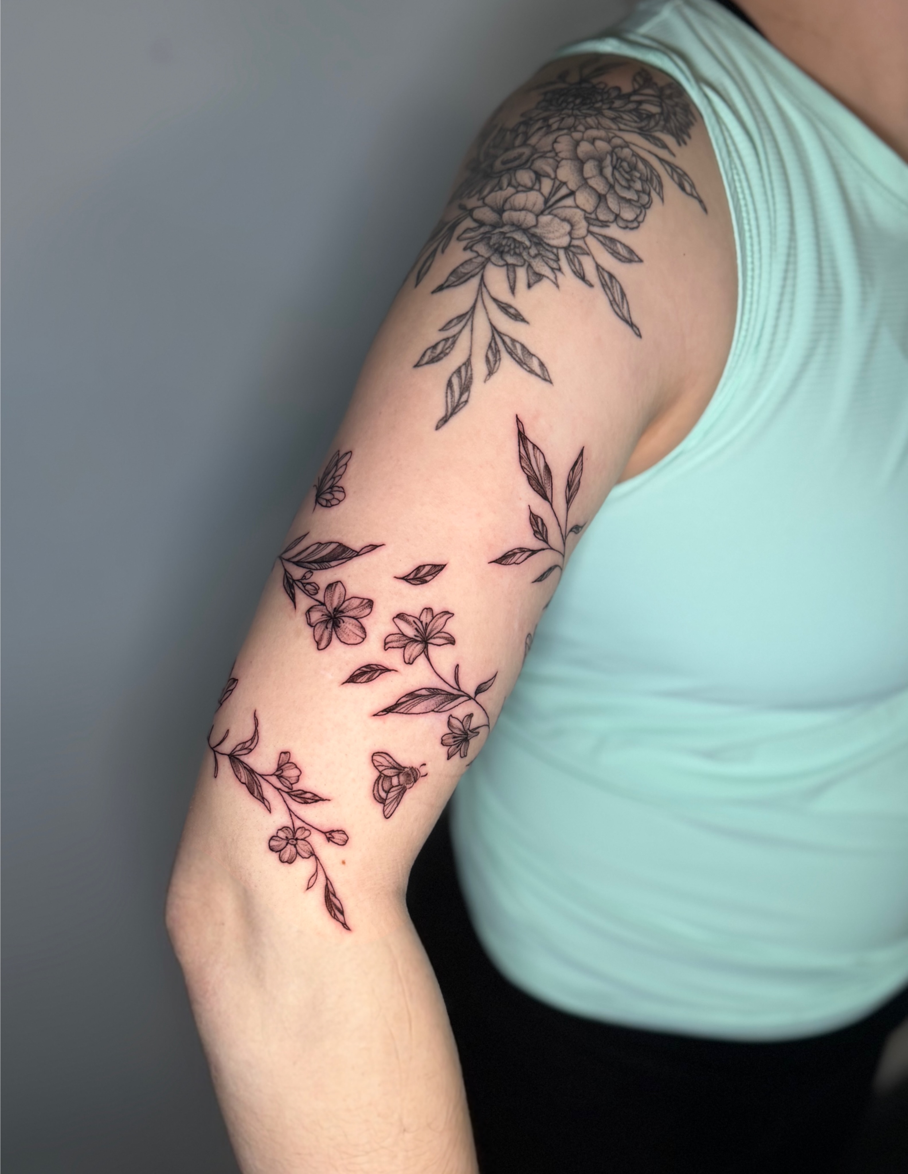 Floral bouquet fine line tattoo on the forearm by Mandy Kaur