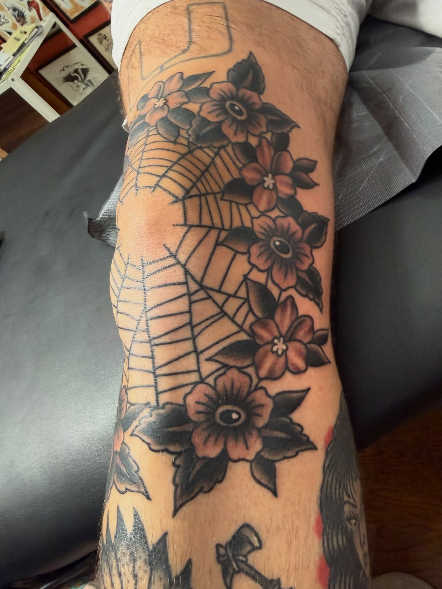 Spider web and flowers American traditional tattoo on the forearm by Cody Dalton