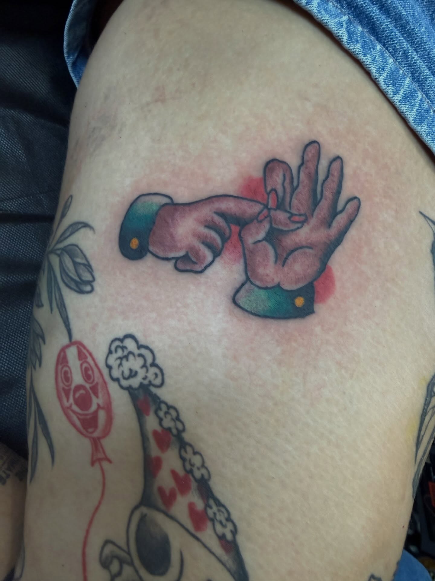 Hands and balloon American traditional tattoo on the thigh by Cody Dalton