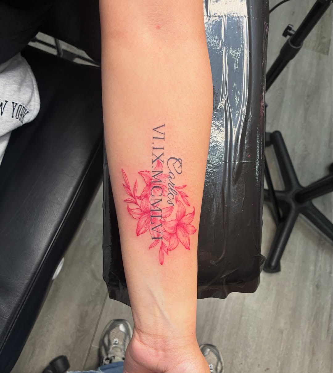 Red lilies watercolor tattoo on the forearm by Tattoos by Hailey