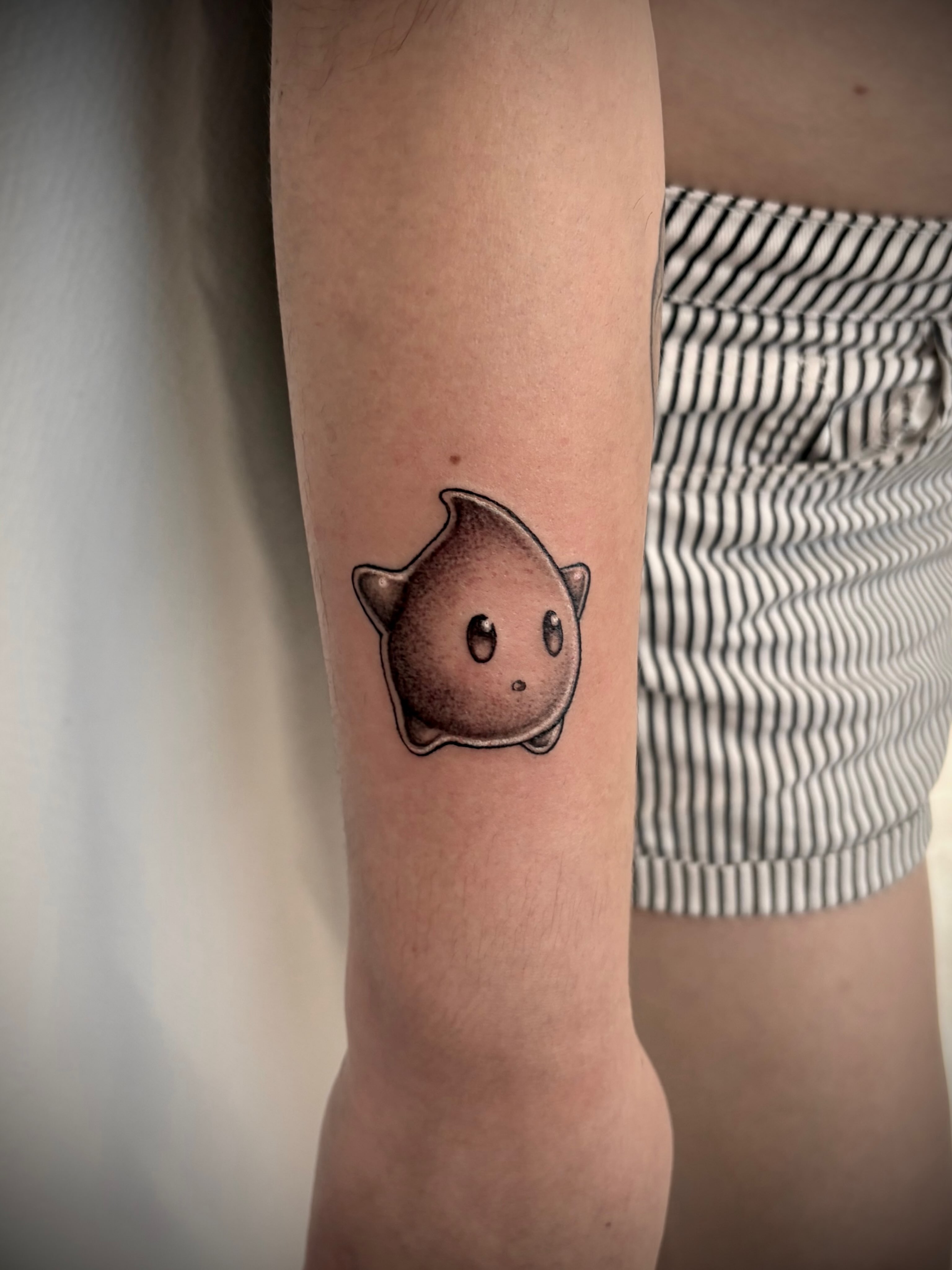 Chibi creature dotwork tattoo on the forearm by Deborah