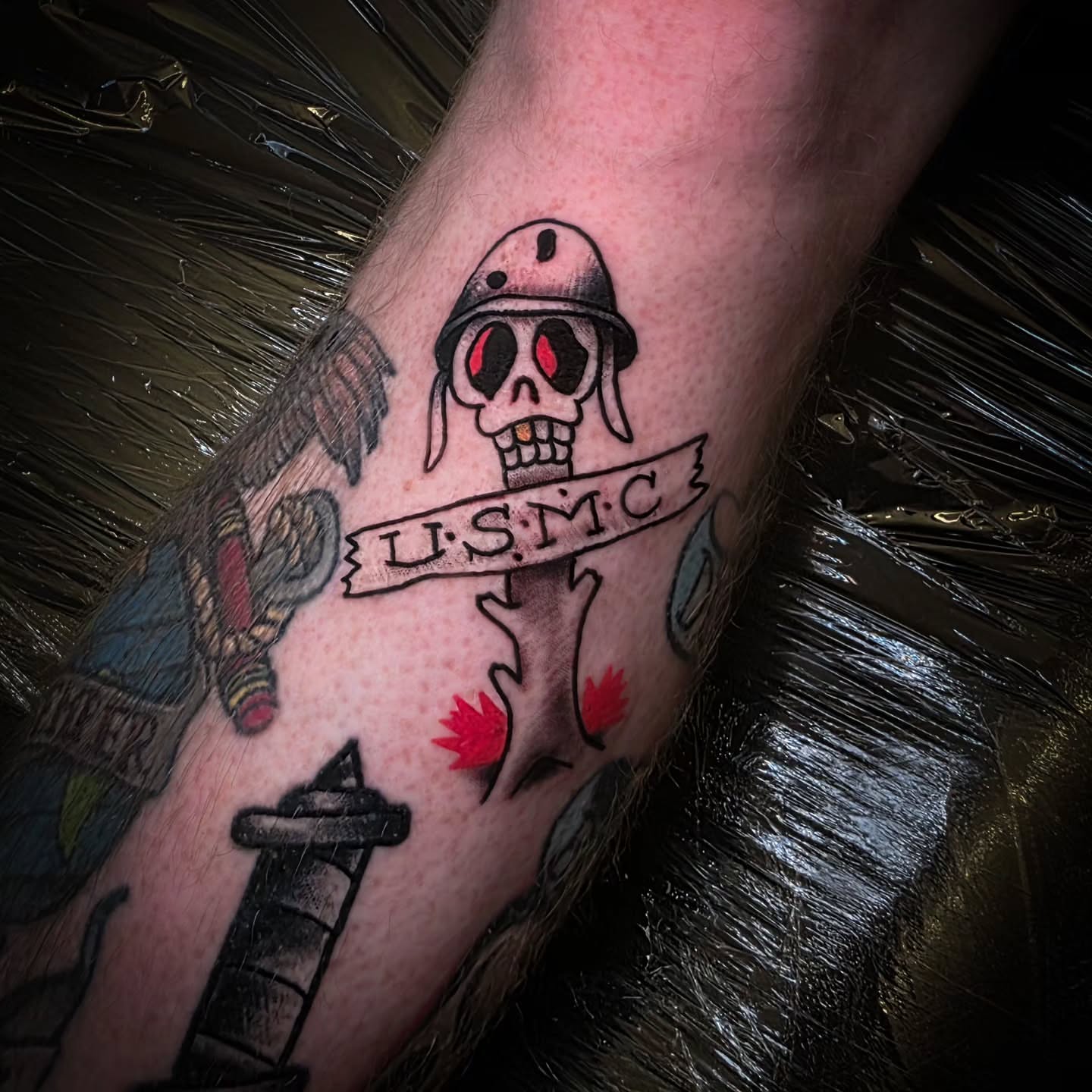 Skull wearing helmet American traditional tattoo on the forearm by John Christo Blake