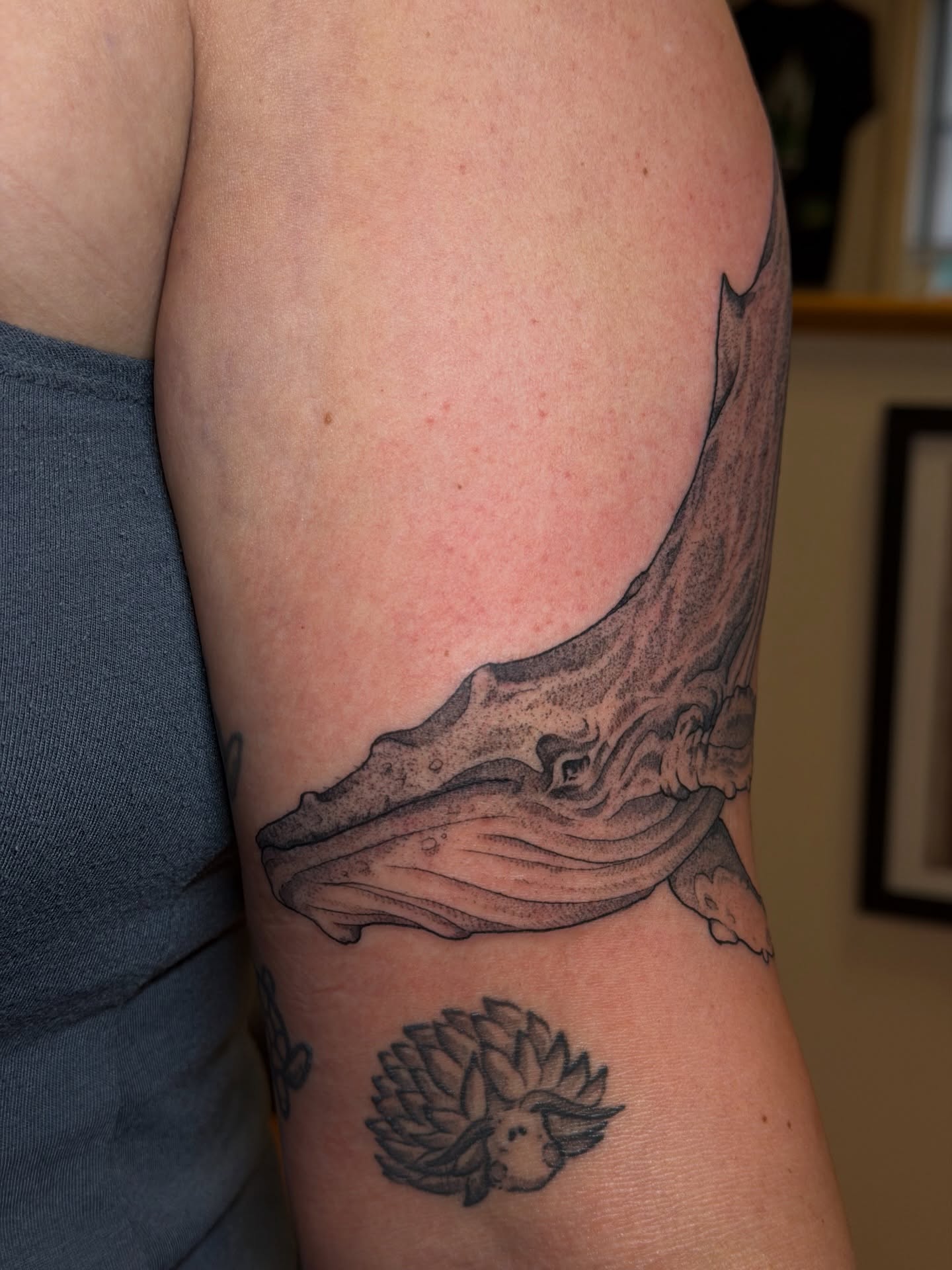 Whale black and grey tattoo on the upper arm by Gianna Calisi