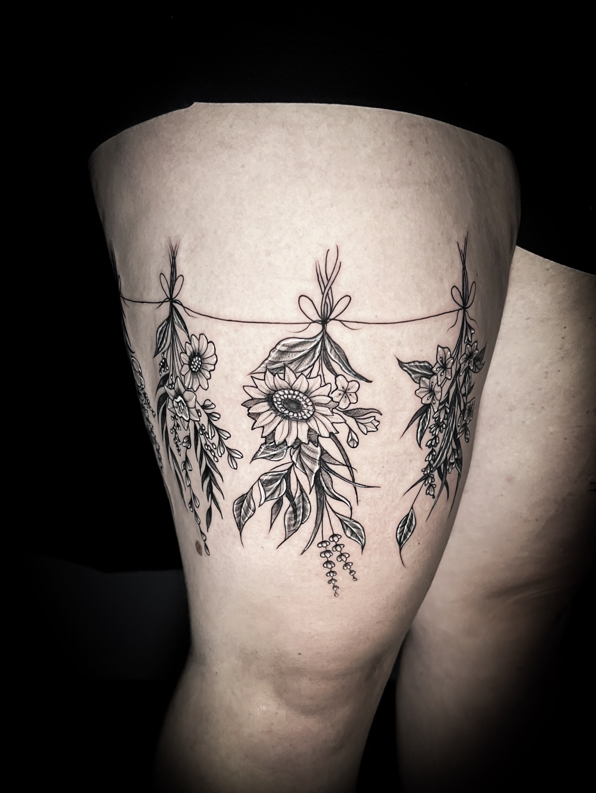 Flower arrangement black and grey tattoo on the thigh by Lindsay Fernandez, Colorado Springs, Colorado