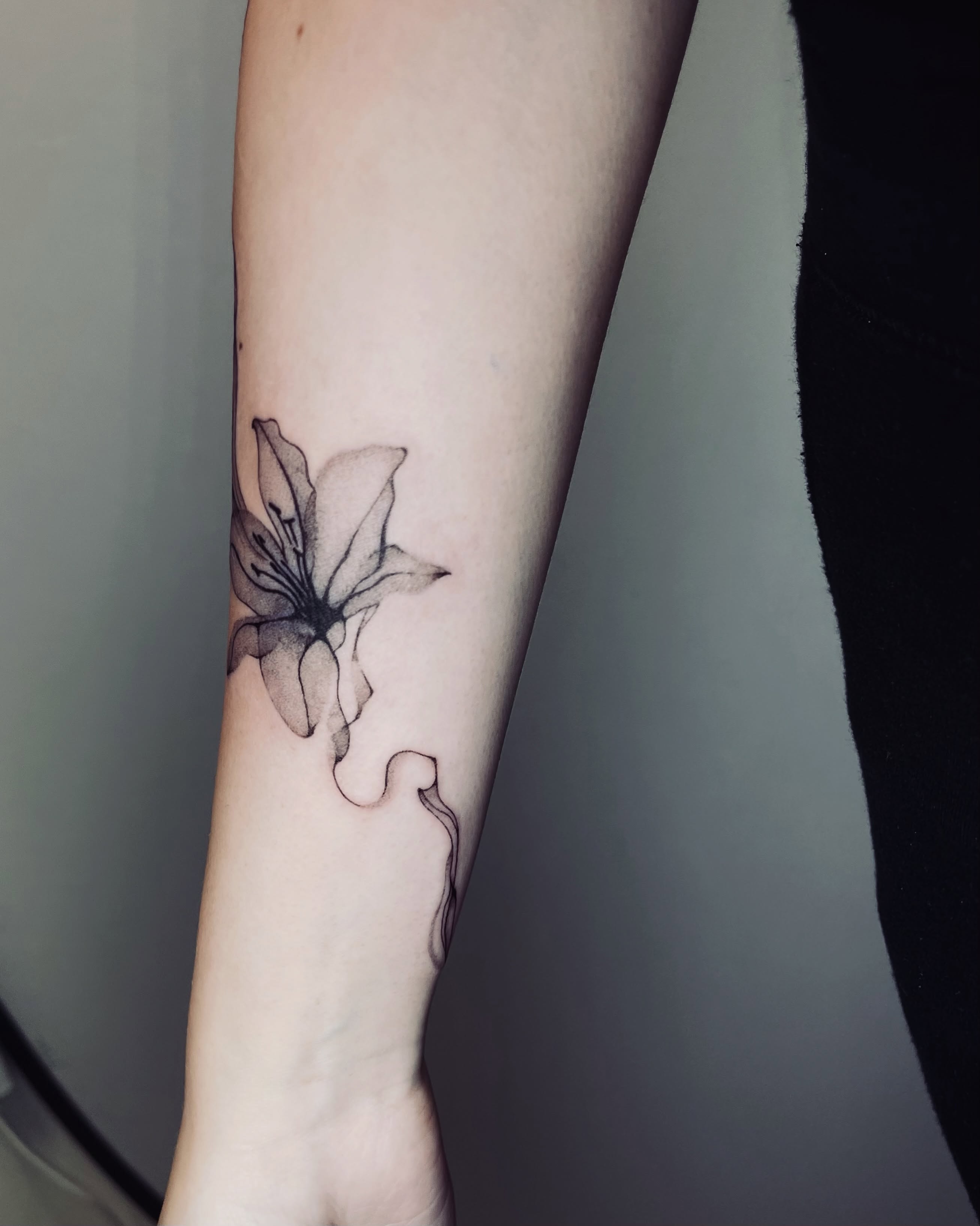 Lily black and grey tattoo on the forearm by vivian