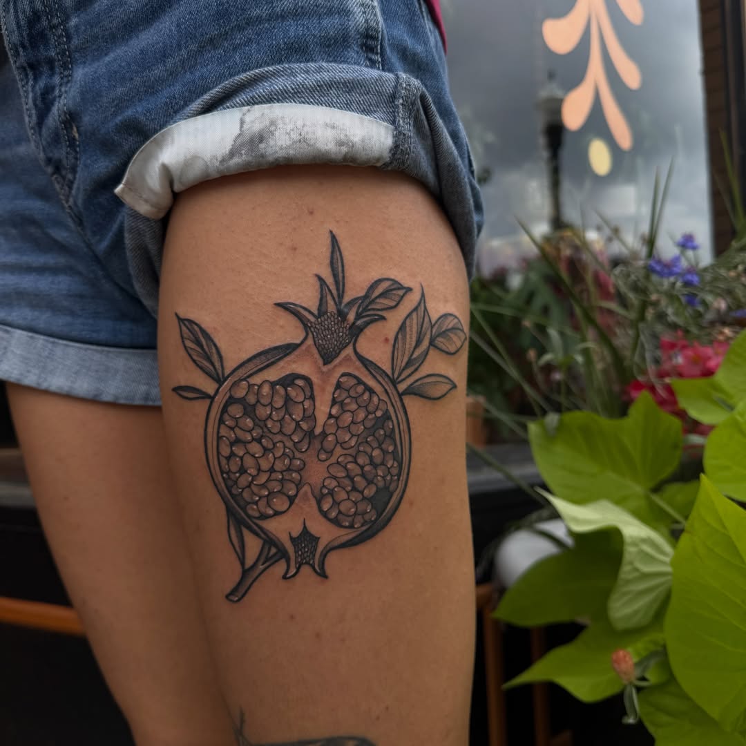 Pomegranate black and grey tattoo on the thigh by Allison