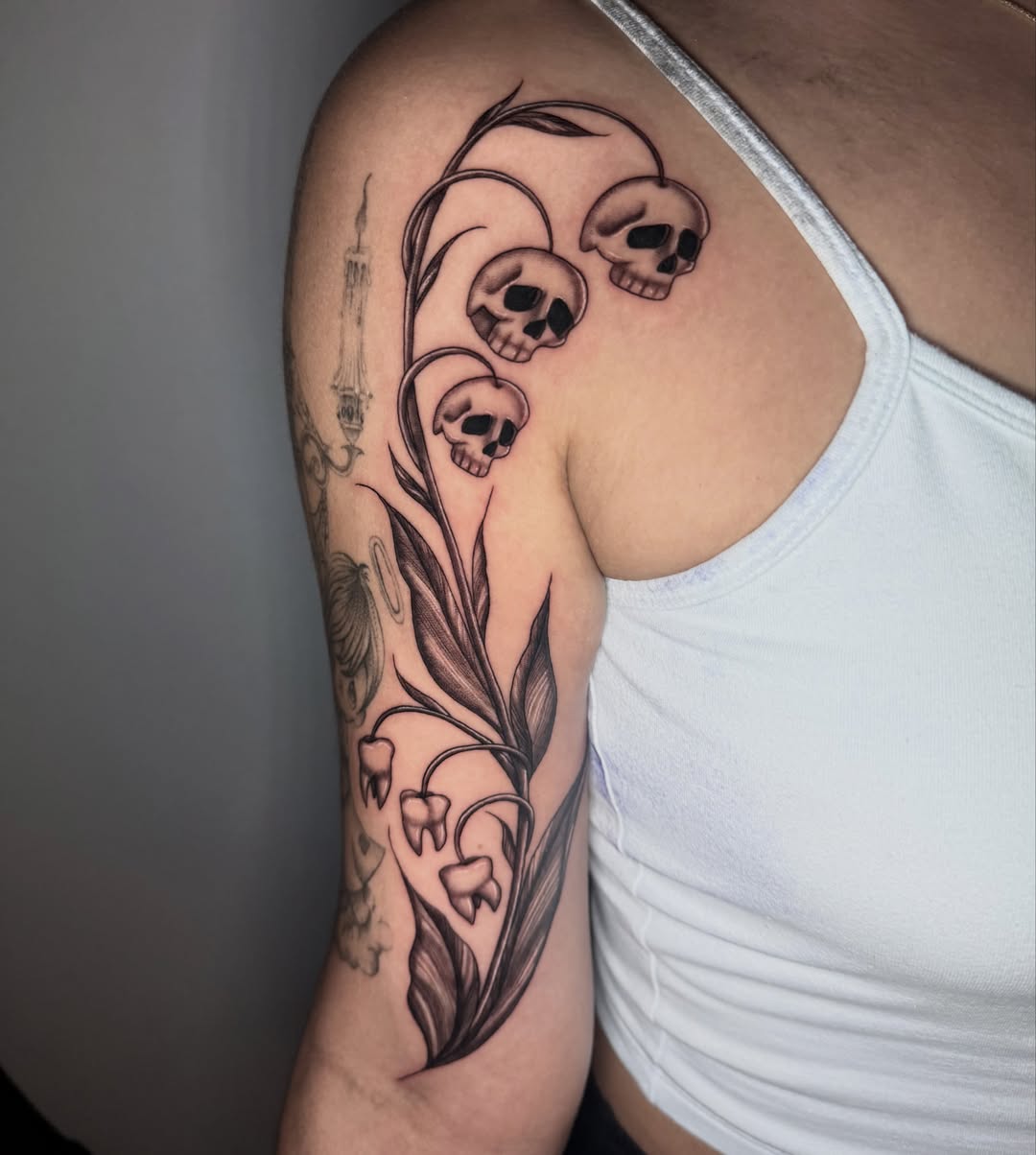Skulls and lilies of the valley realism tattoo on the shoulder by 𝖎𝖘𝖆 ✶ 𝖉𝖋𝖜 𝖙𝖆𝖙𝖙𝖔𝖔𝖘
