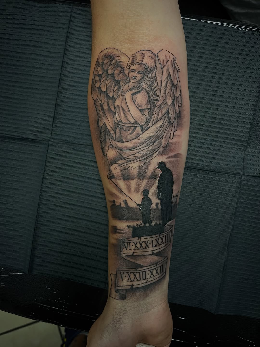 Angel and fishing scene realism tattoo on the forearm by Chris Torres