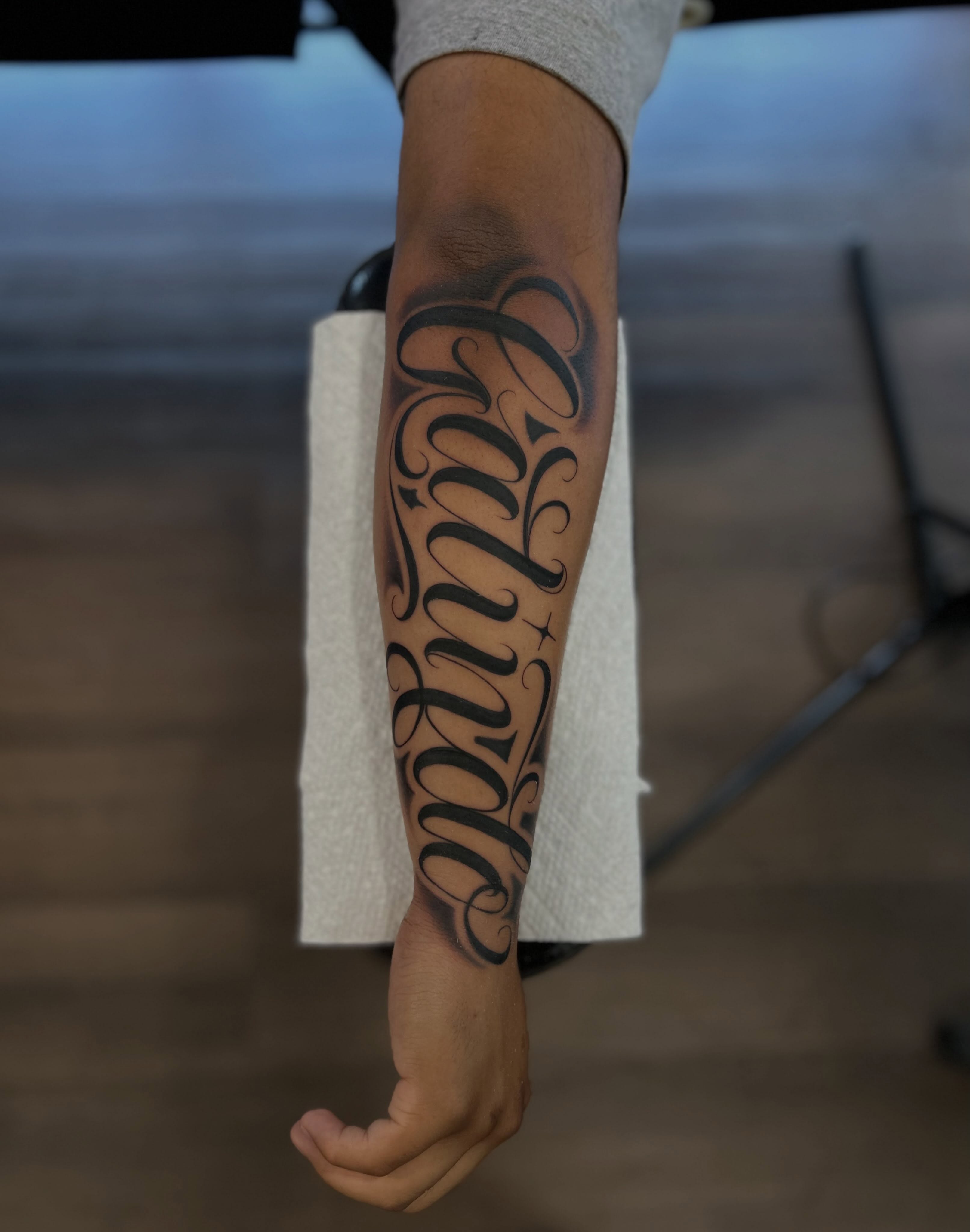 Script lettering lettering script tattoo on the forearm by Tattoo Artist