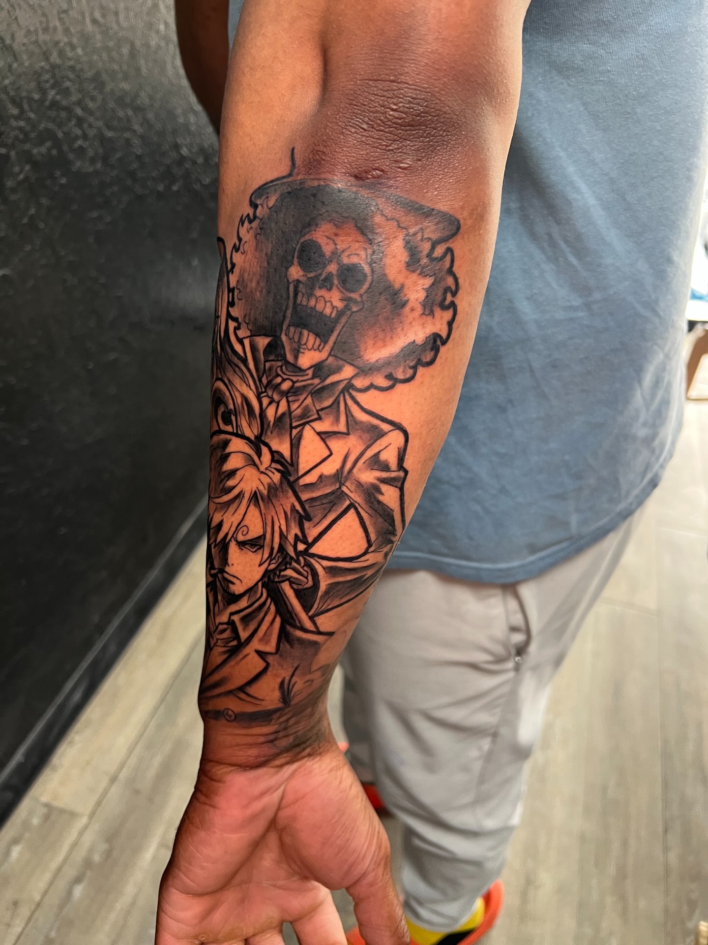 Skull and man black and grey tattoo on the forearm by Justx4rt