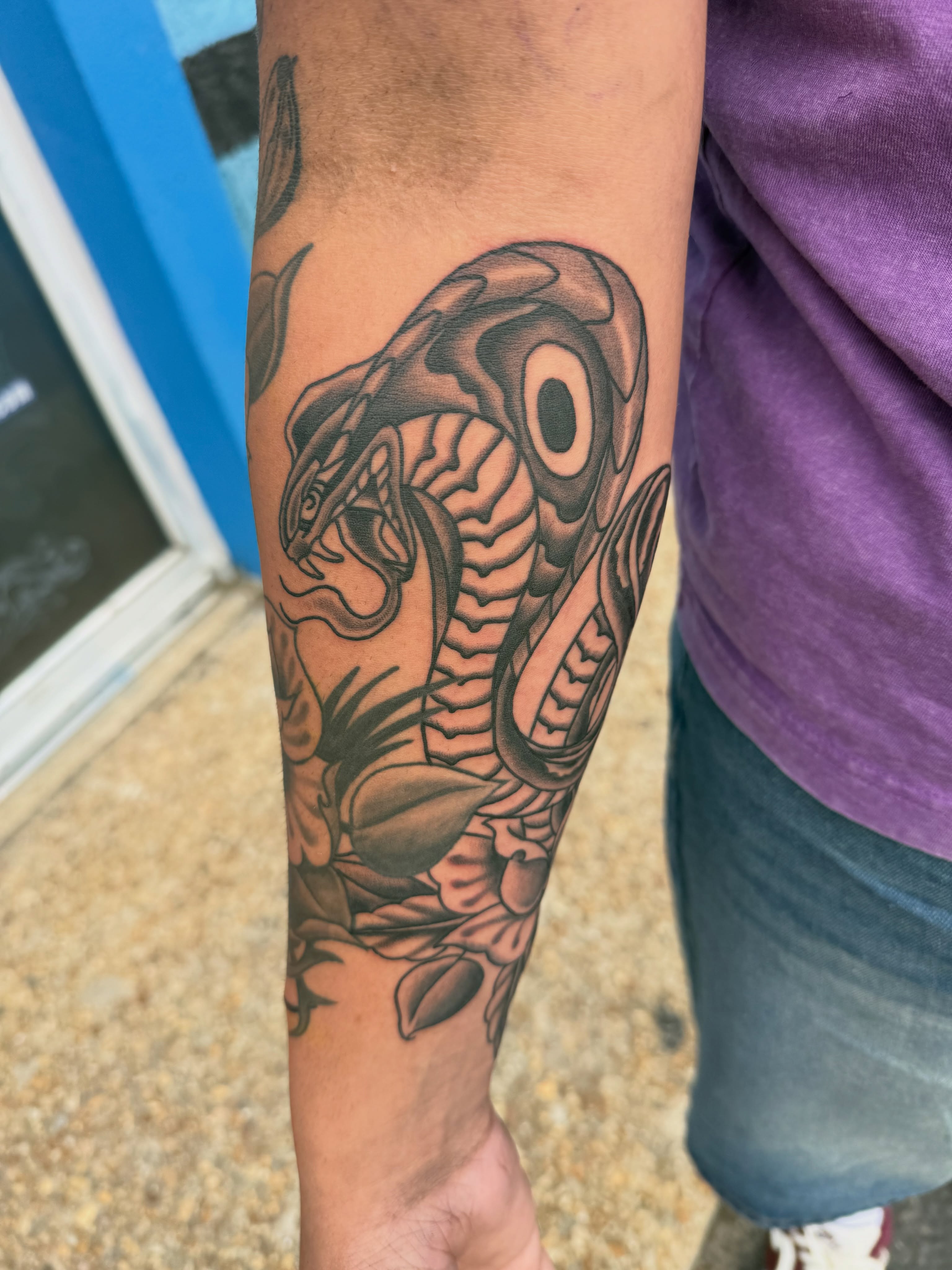 Snake and peony black and grey tattoo on the forearm by Blue Horseshoe Tattoo & Body Piercing