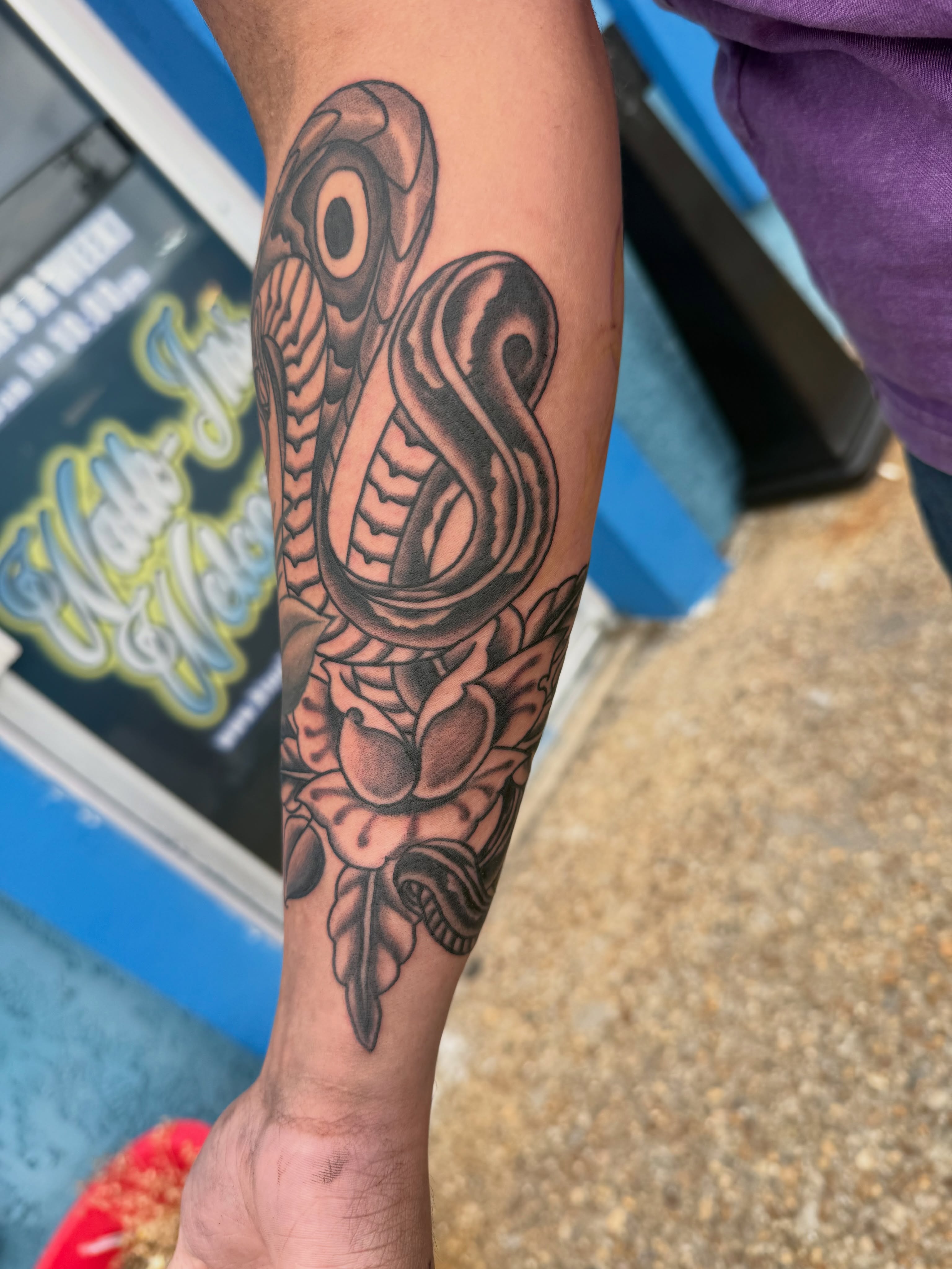 Snake and peony black and grey tattoo on the forearm by Blue Horseshoe Tattoo & Body Piercing