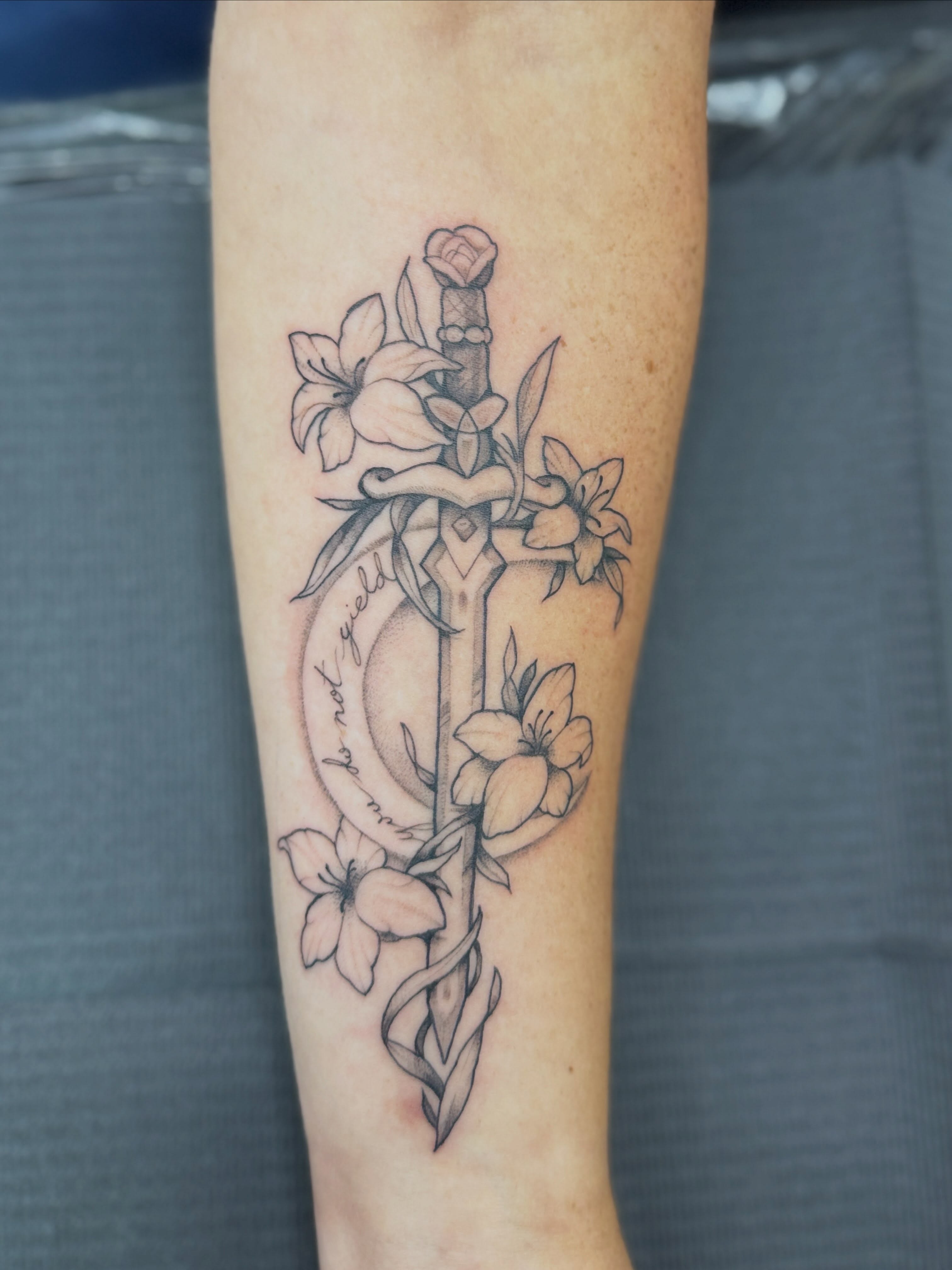 Sword and flowers black and grey tattoo on the forearm by Rebecca Rose