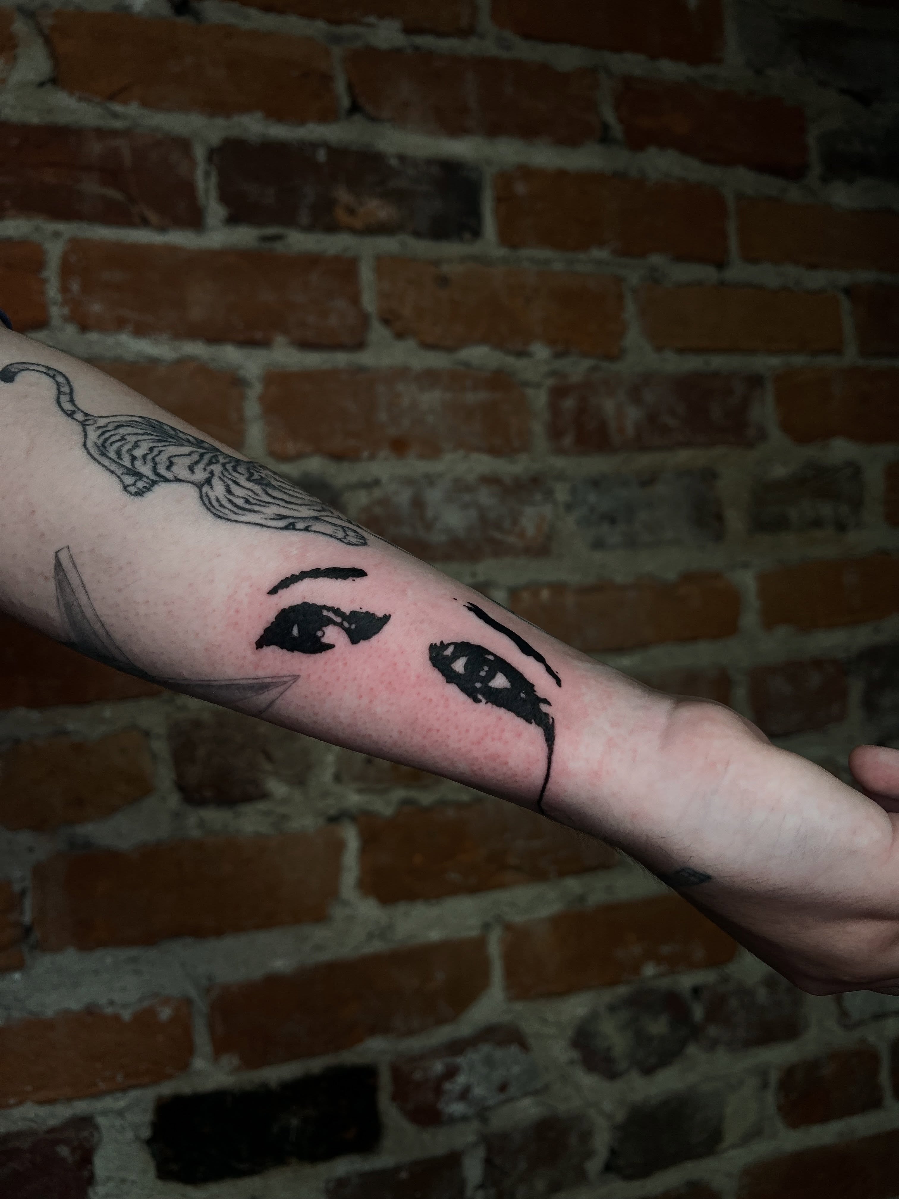 Woman's face black and grey tattoo on the forearm by Uncomfy Comfort Tattoos LLC