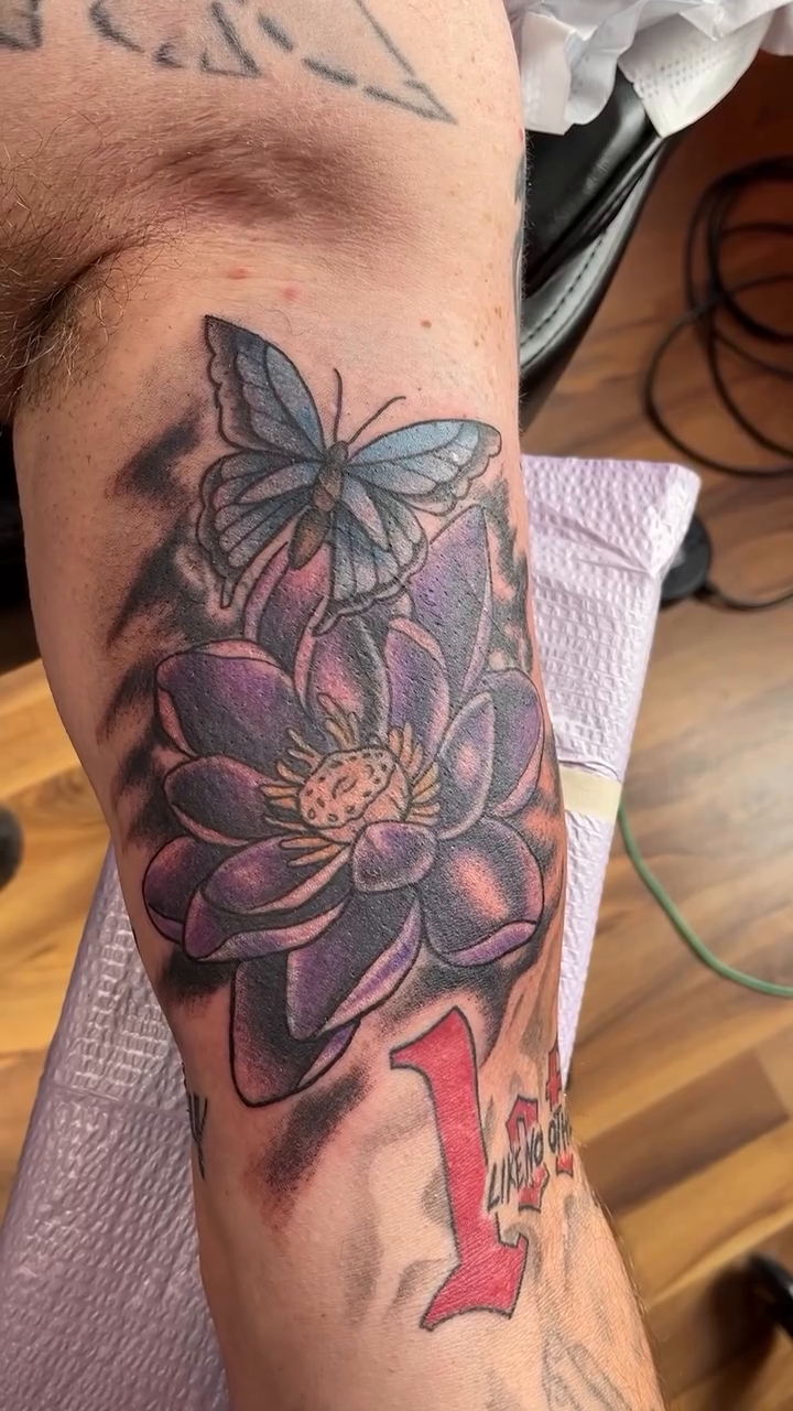 Lotus flower and butterfly fine line tattoo on the upper arm by Cortney "Fett" Fettinger, Fort Wayne, Indiana