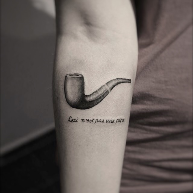 Pipe with text minimalist tattoo on the forearm by Yana Aizen