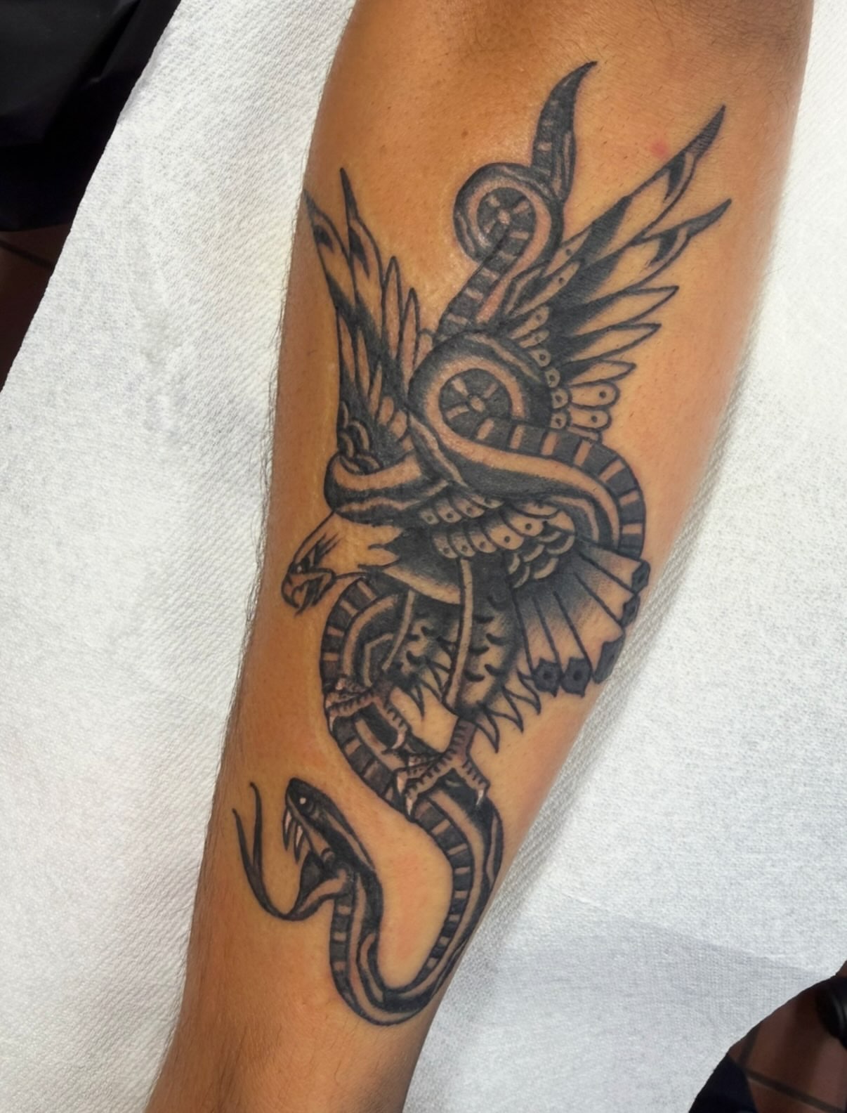 Snake and wings black and grey tattoo on the forearm by David Evans