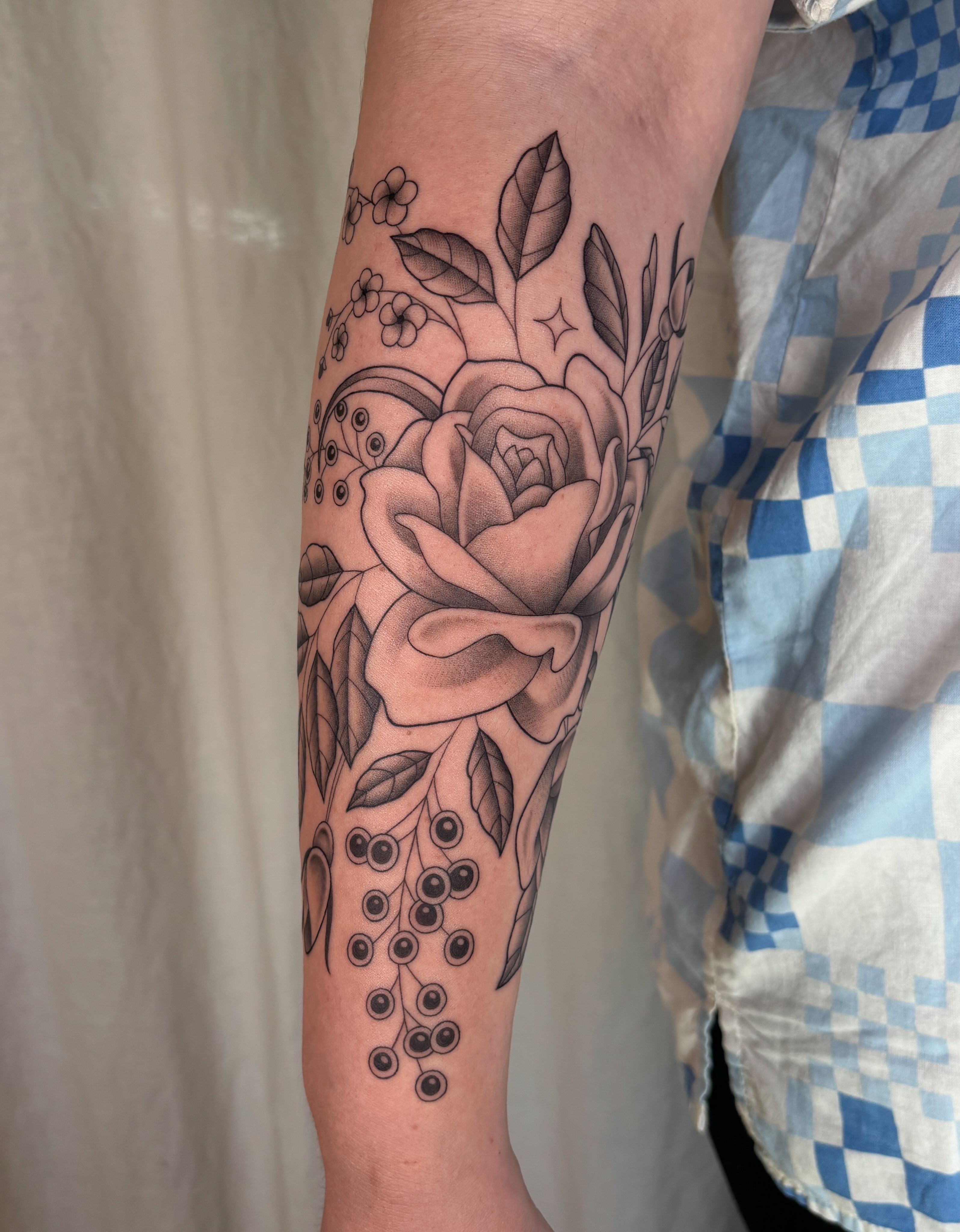Rose and floral arrangement realism tattoo on the forearm by Anna Sage