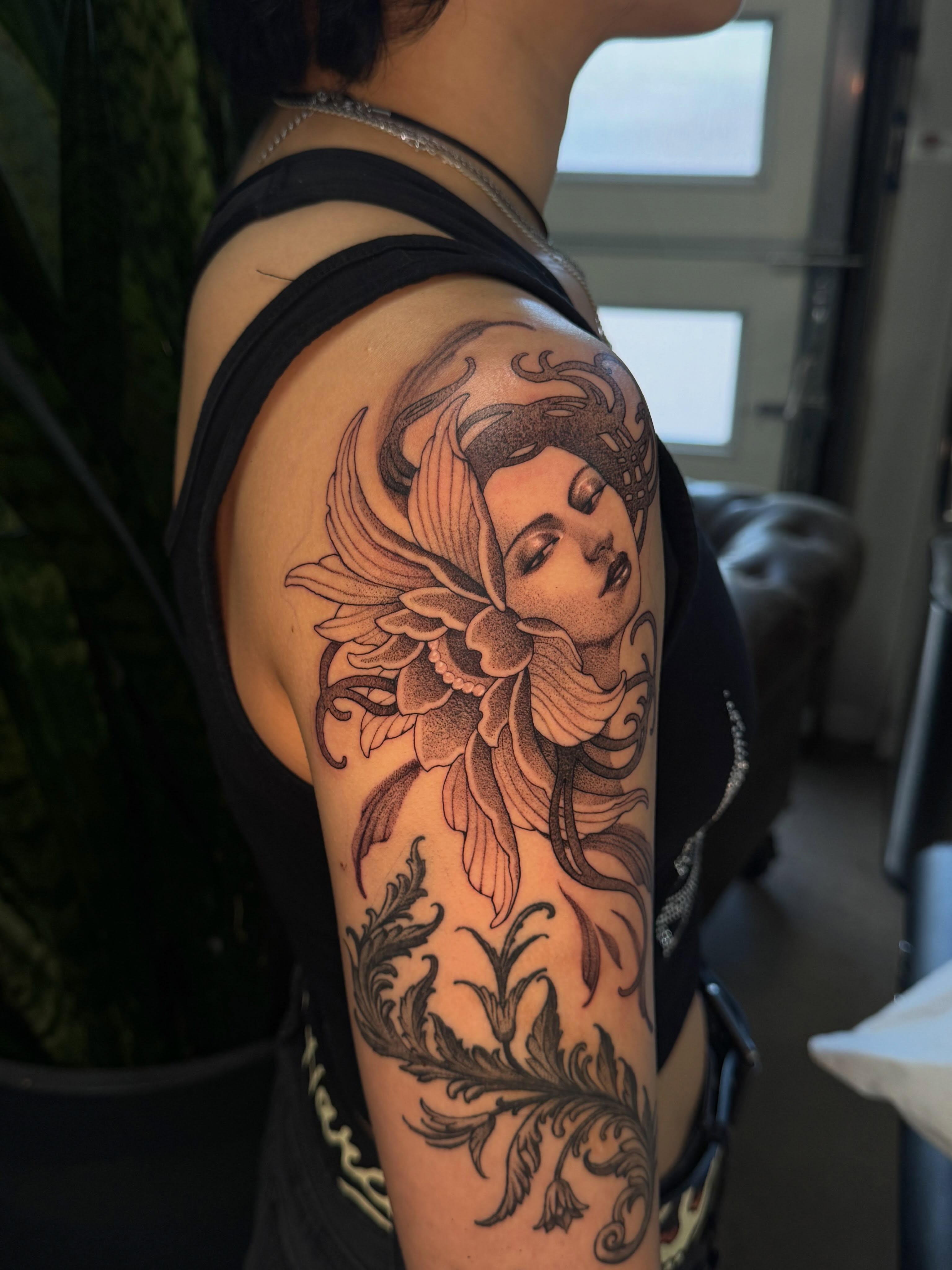 Floral woman dotwork tattoo on the upper arm by Marina Spell
