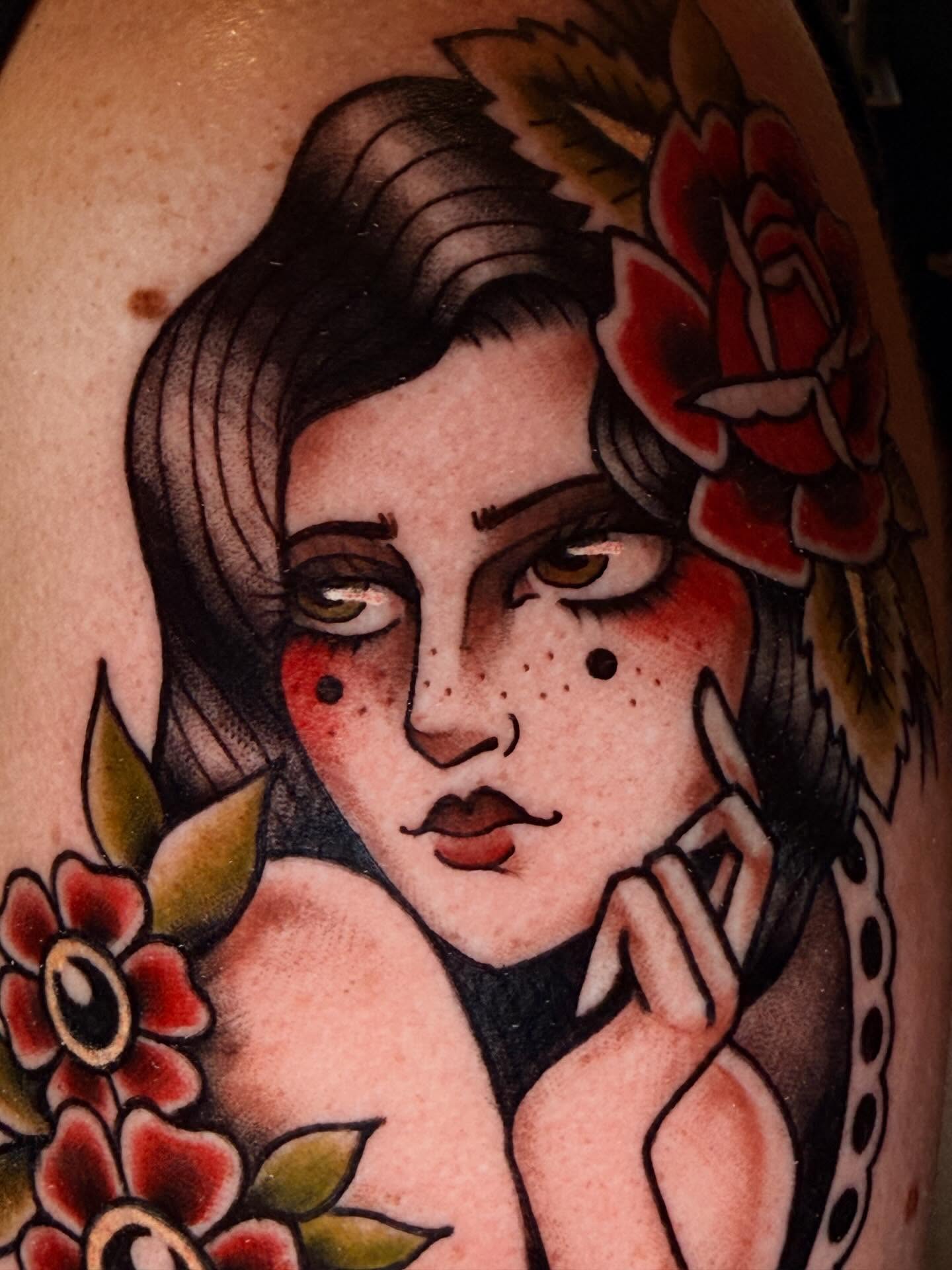 Woman with flowers American traditional tattoo on the shoulder by Jessica Haug