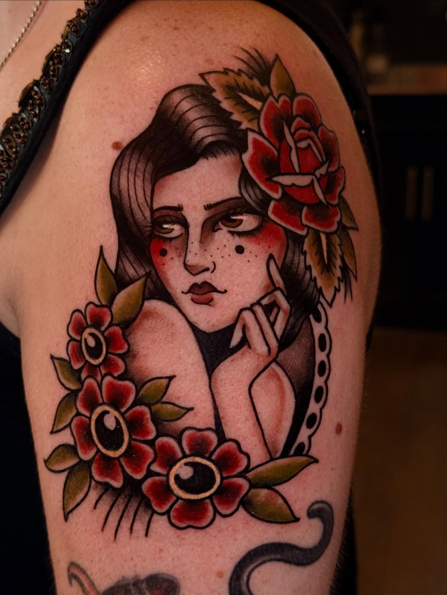 Woman with flowers American traditional tattoo on the shoulder by Jessica Haug