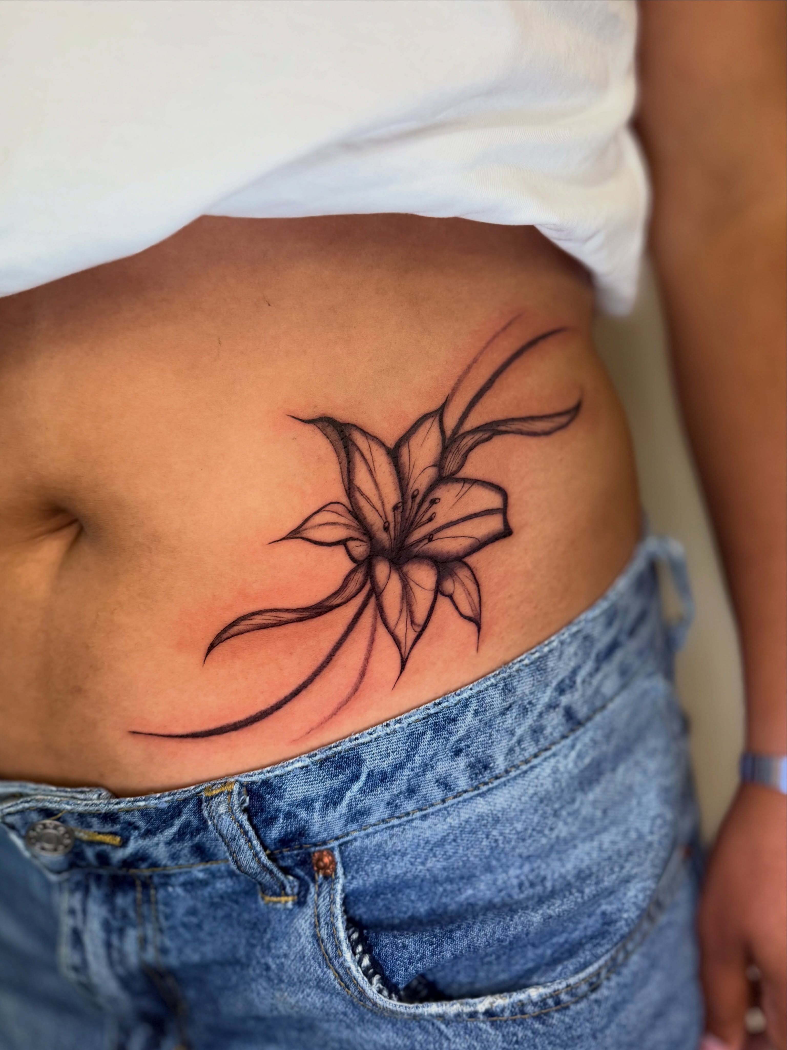 Lily black and grey tattoo on the ribs by Bryan Nguyen