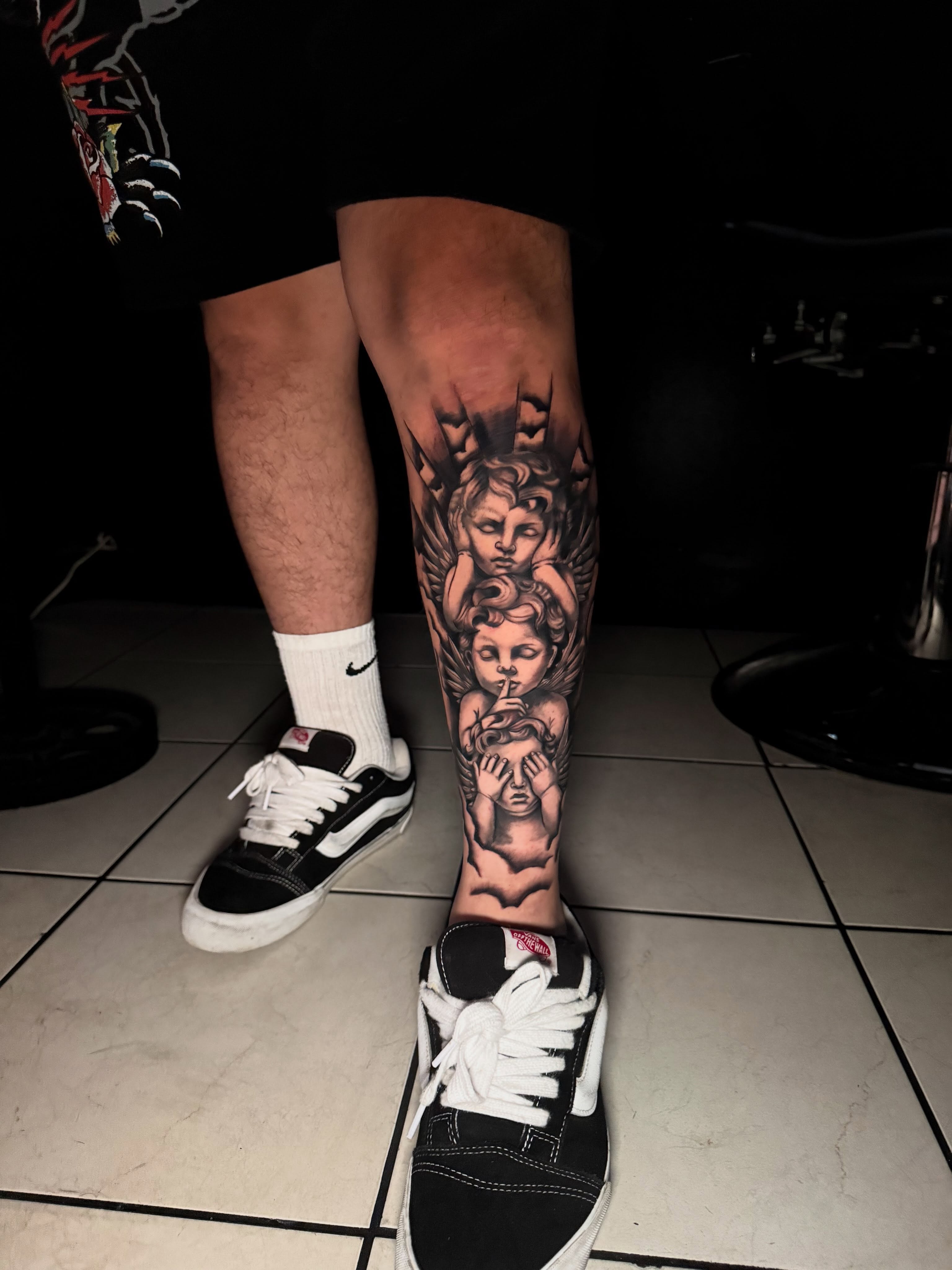 Cherubs black and grey tattoo on the calf by Jasmin Lozano