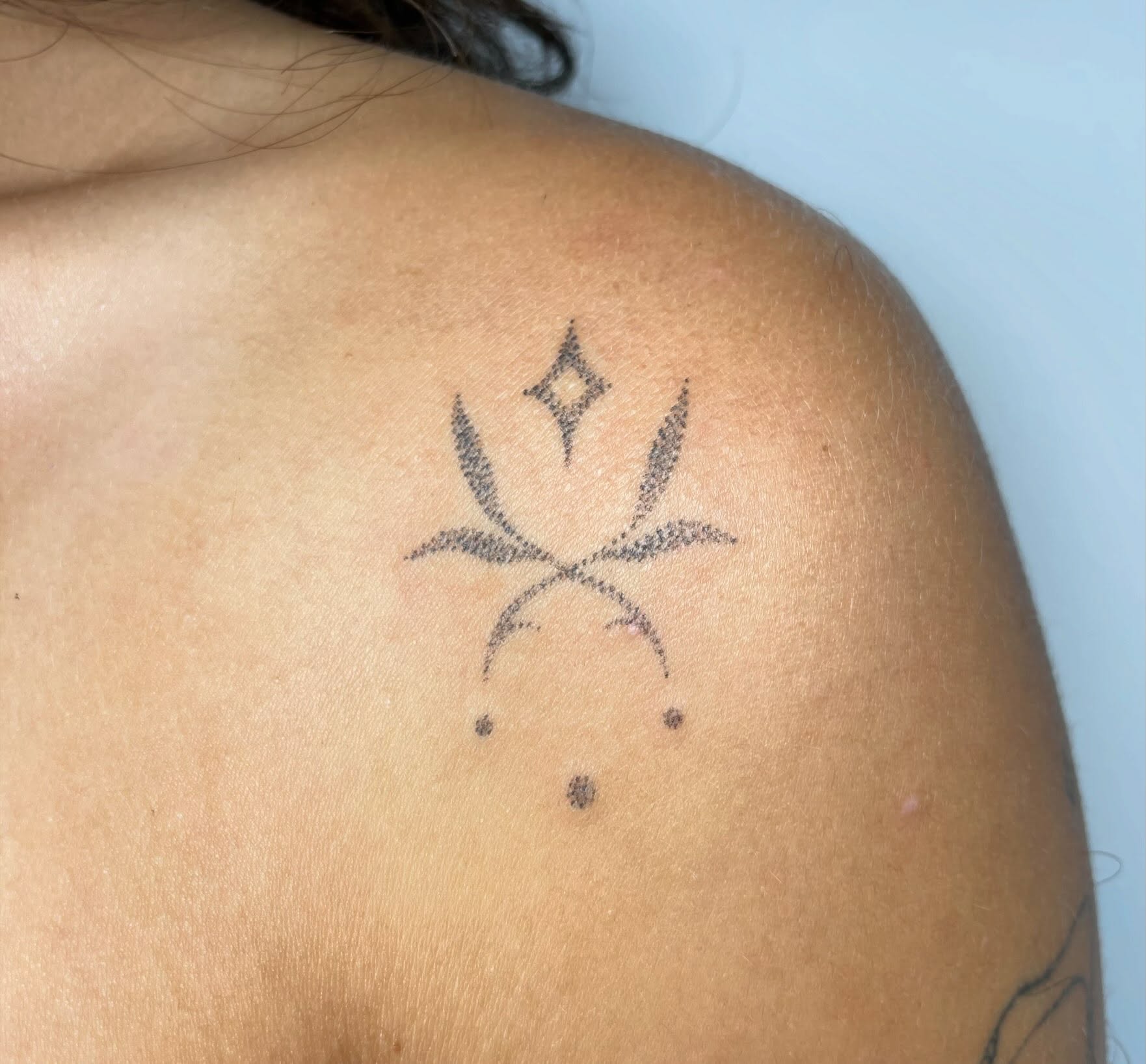 Geometric symbol dotwork tattoo on the shoulder by Quin
