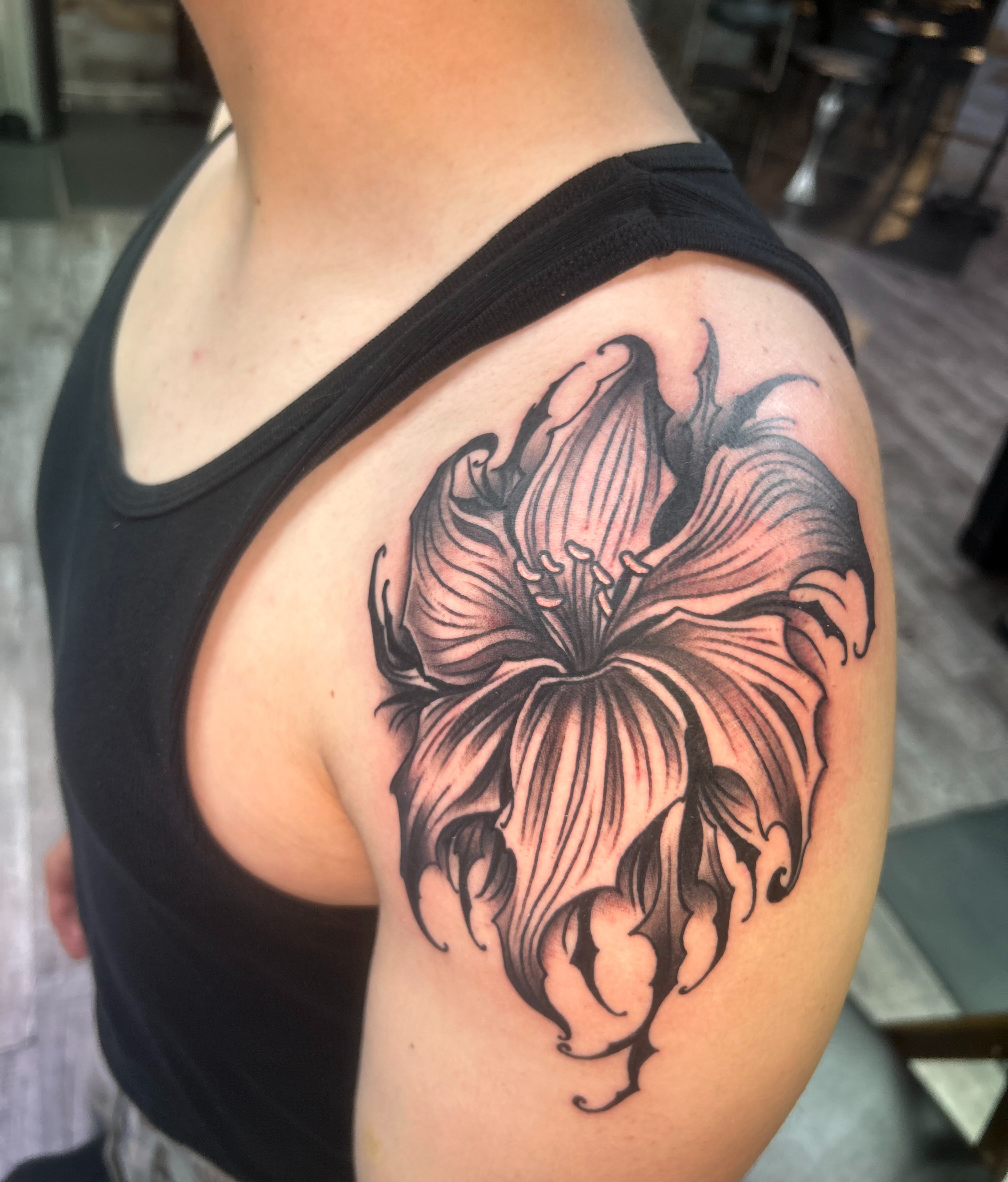 Lily black and grey tattoo on the shoulder by Daemion