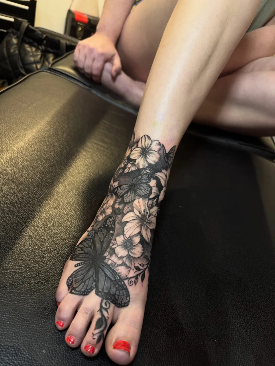 Butterfly and flowers black and grey tattoo on the foot by lizzy, Damascus, Maryland