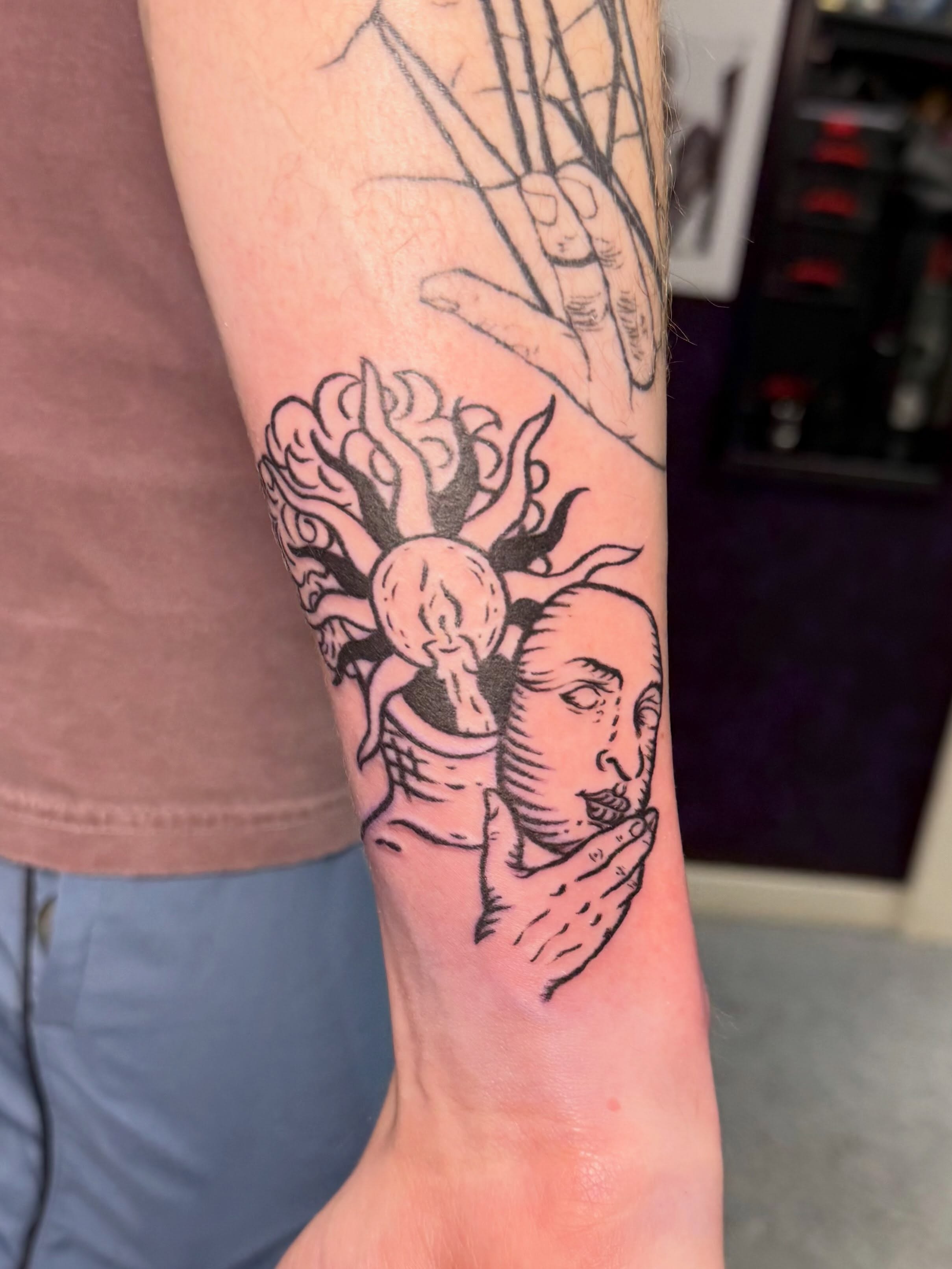 Head with flame black and grey tattoo on the forearm by Taylor Kay 🌿