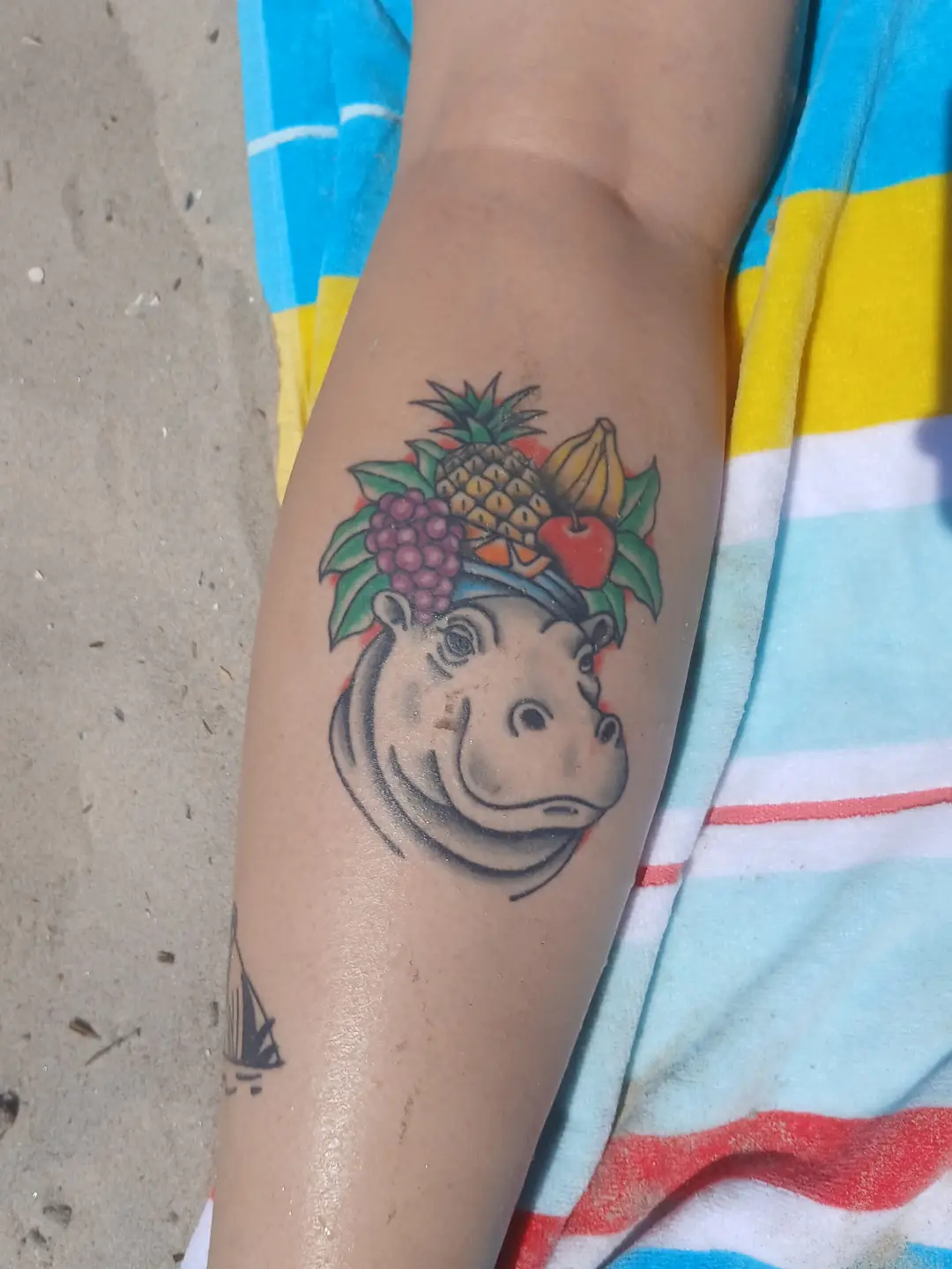 Hippo with fruit crown American traditional tattoo on the forearm by Amber Tattoos