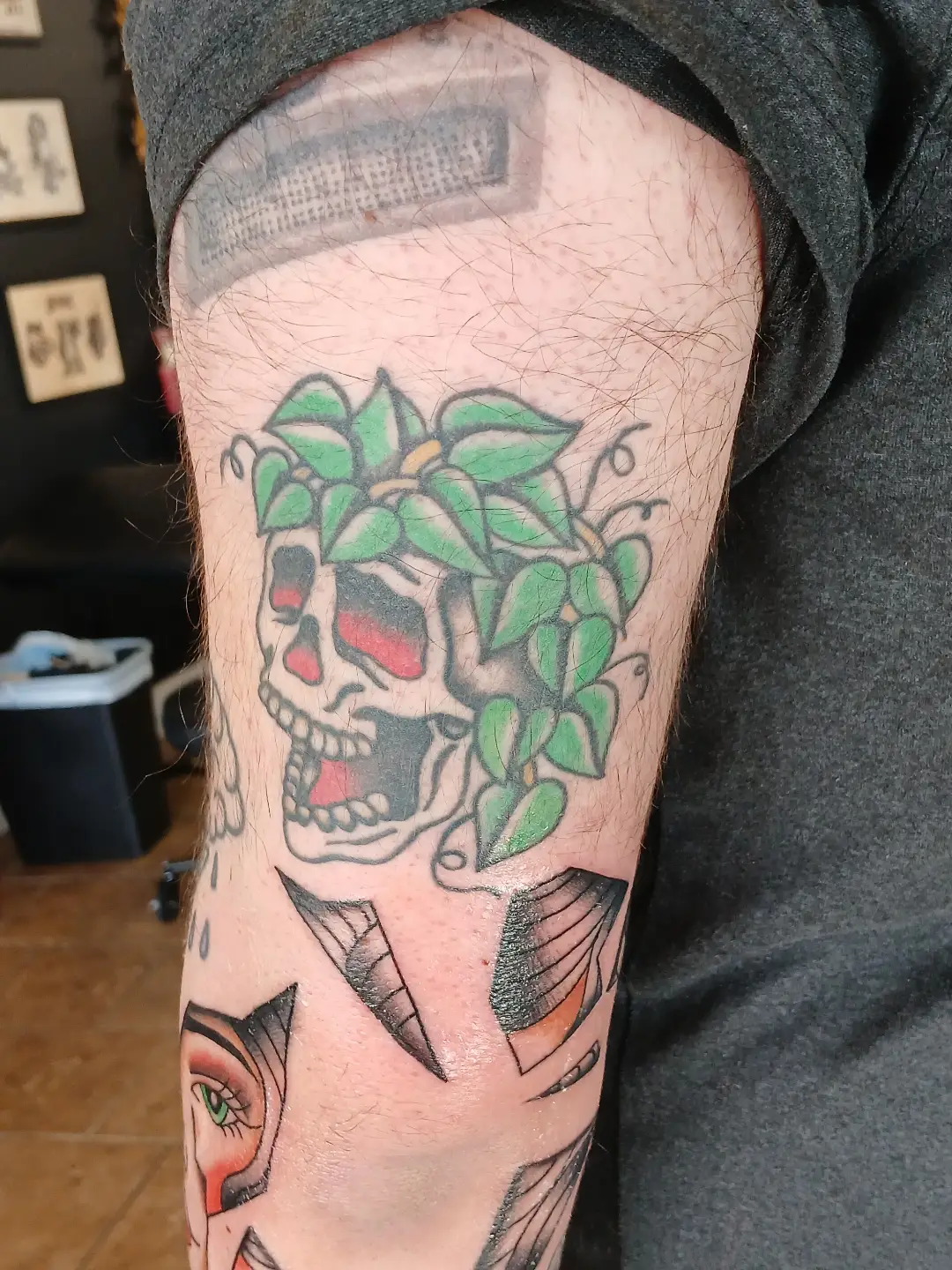 Skull with leaves American traditional tattoo on the forearm by Amber Tattoos