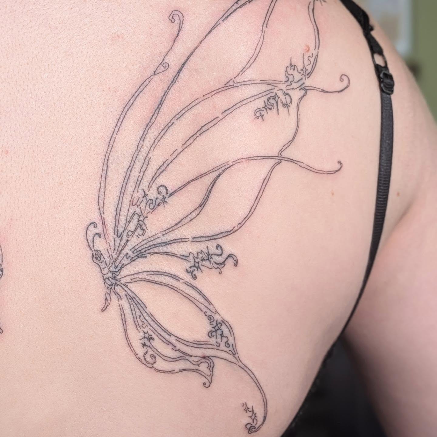 Butterfly fine line tattoo on the shoulder by Ryan