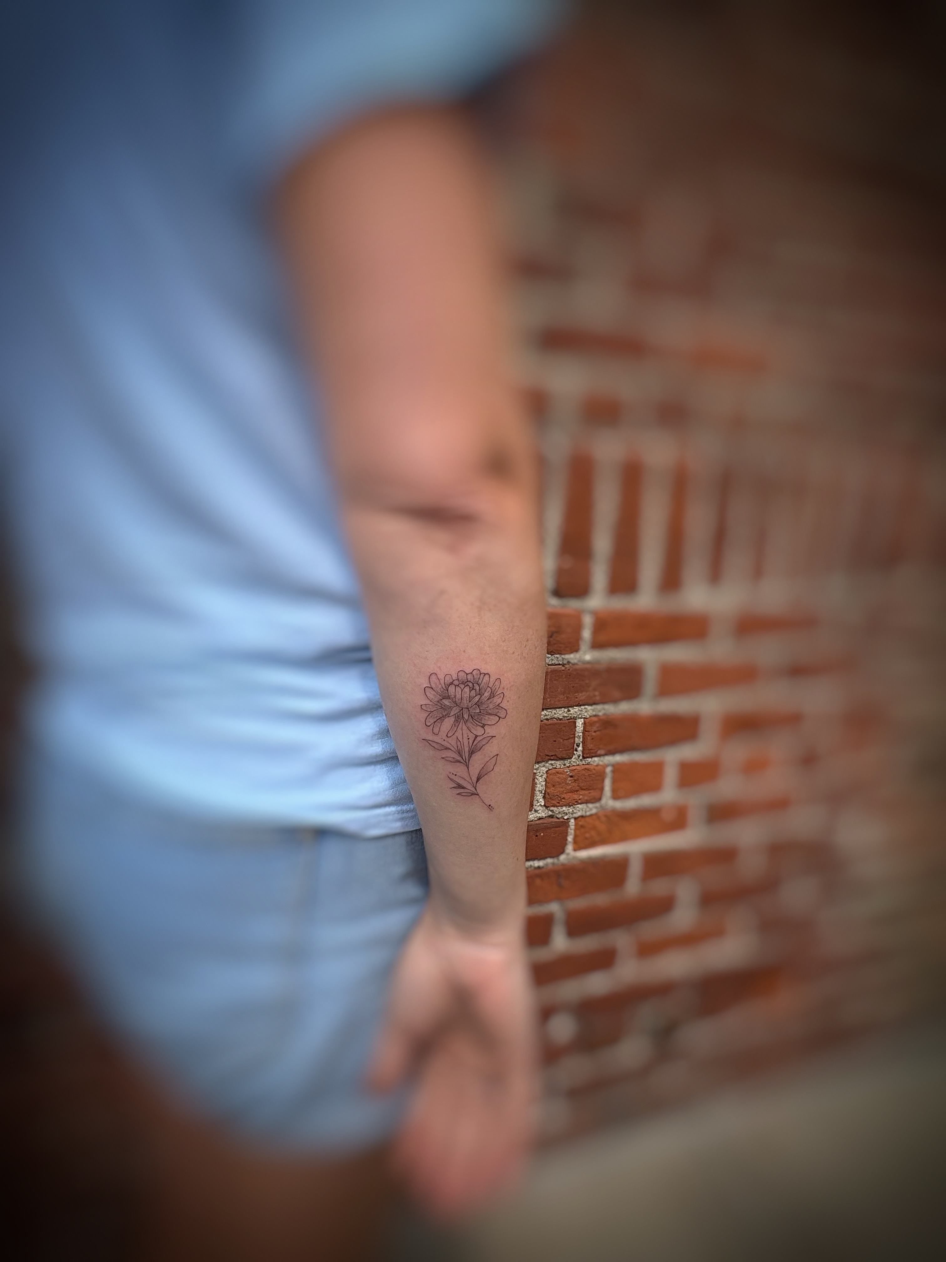 Flower black and grey tattoo on the forearm by Holly