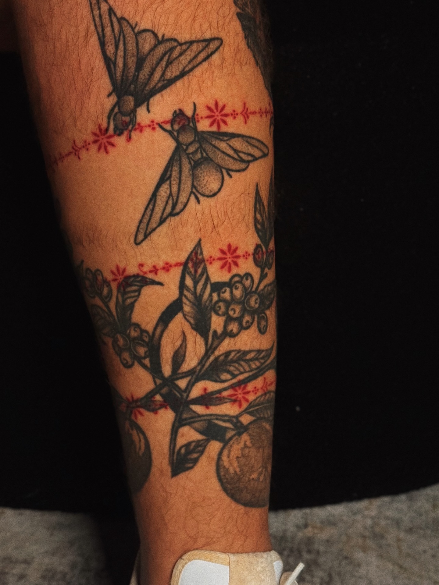 Insects and fruit black and grey tattoo on the forearm by Luisa Duarte