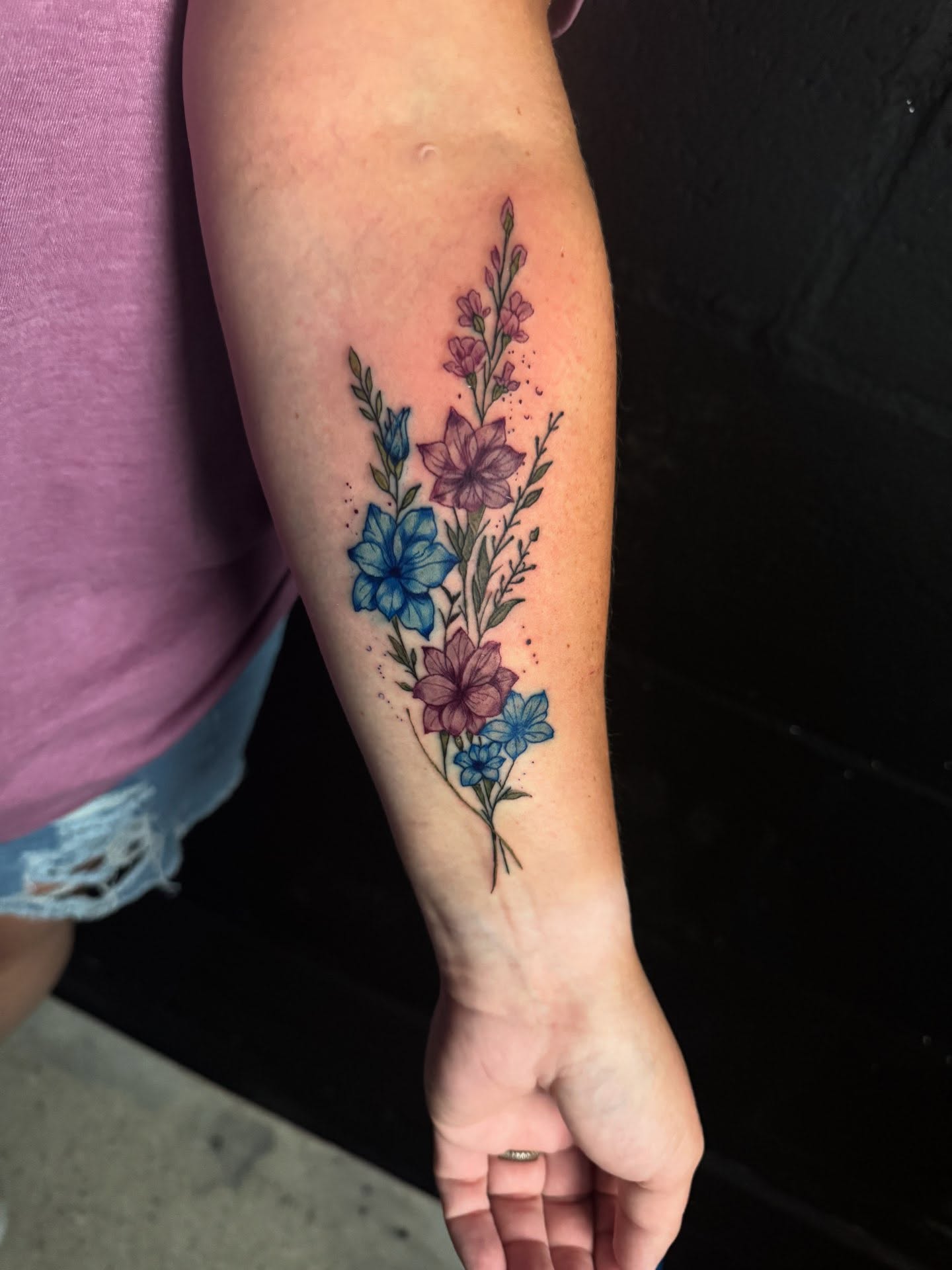 Floral bouquet watercolor tattoo on the forearm by Brandiane Wells